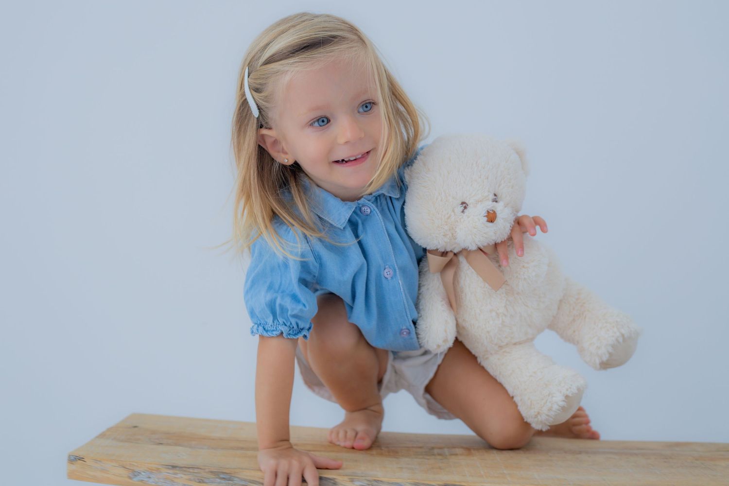 Niña sonriendo con su osito de peluche durante una sesión infantil y familiar en Valdemoro, zona sur de Madrid. Fotografía natural y emotiva