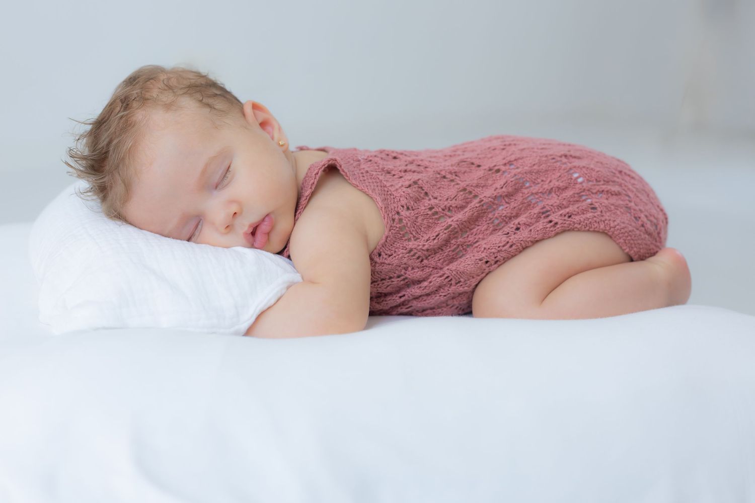 Bebé dormido con mono rosa durante una sesión newborn en Valdemoro, zona sur de Madrid. Fotografía tierna, natural y emocional.