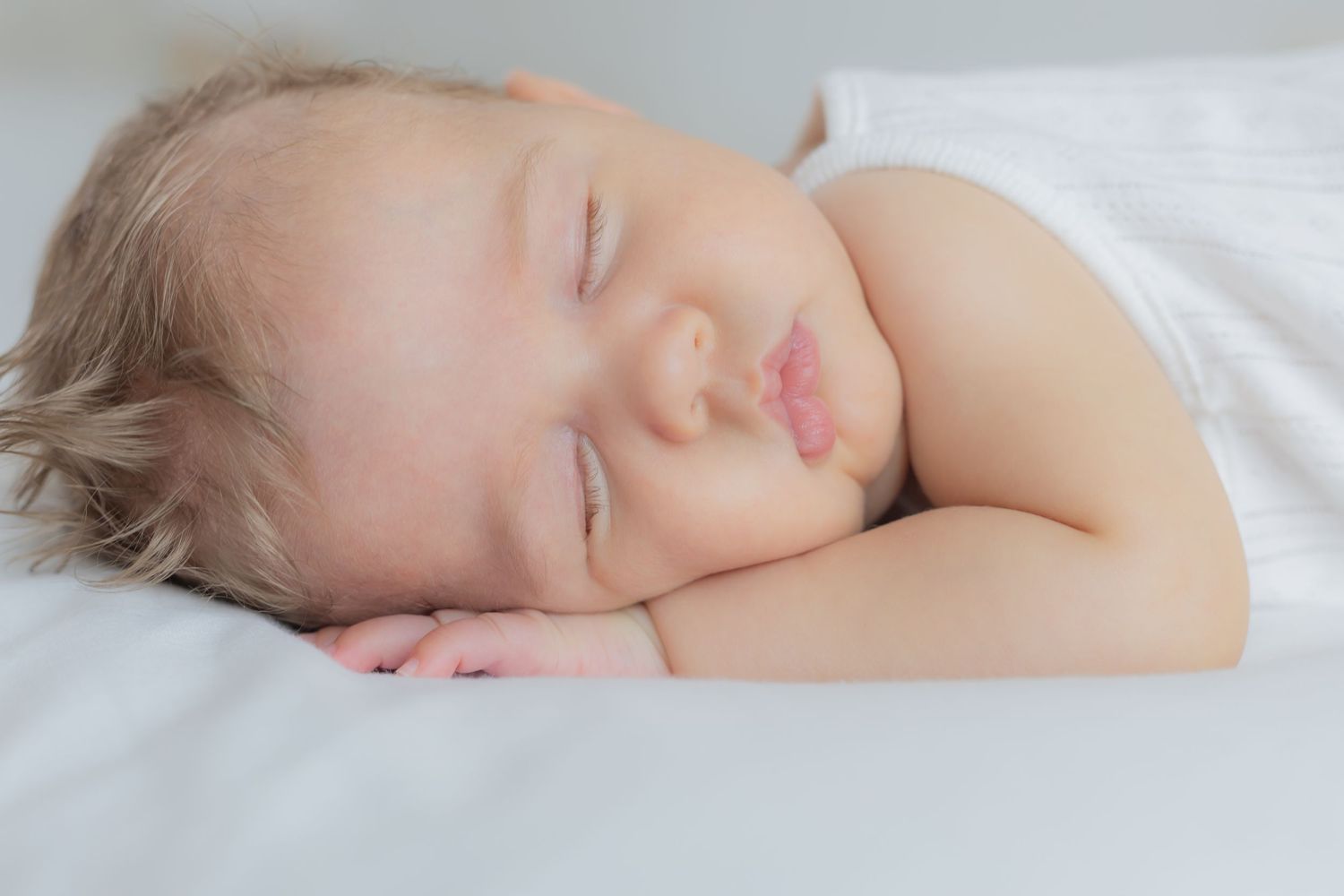 Primer plano de bebé dormido con detalle de su mano durante sesión newborn en Valdemoro, zona sur de Madrid con luz natural y sin posado.