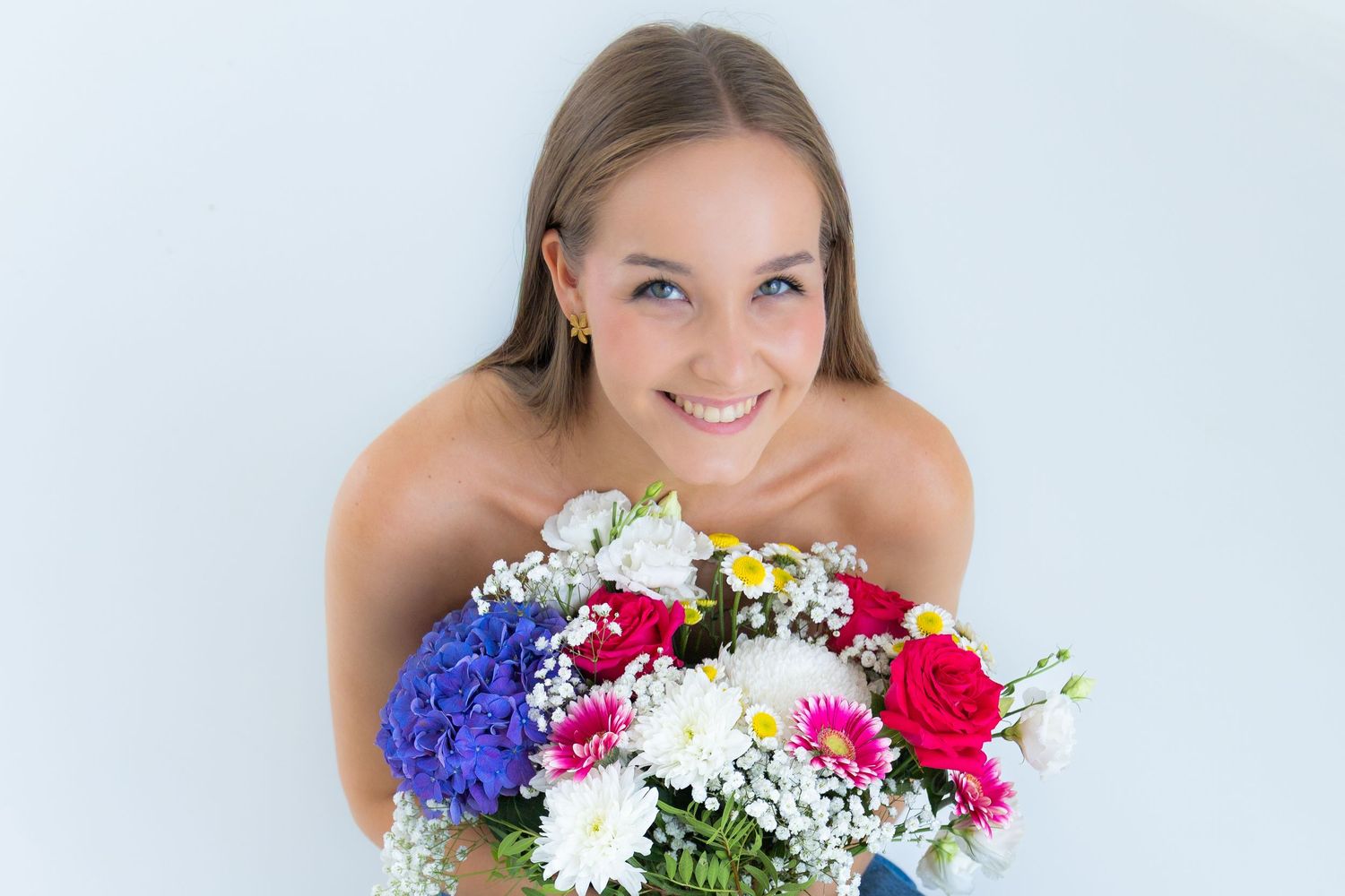 Retrato de una joven sonriendo con un ramo de flores en mini sesión fotografía en Valdemoro, zona sur de Madrid. Fotografía emocional