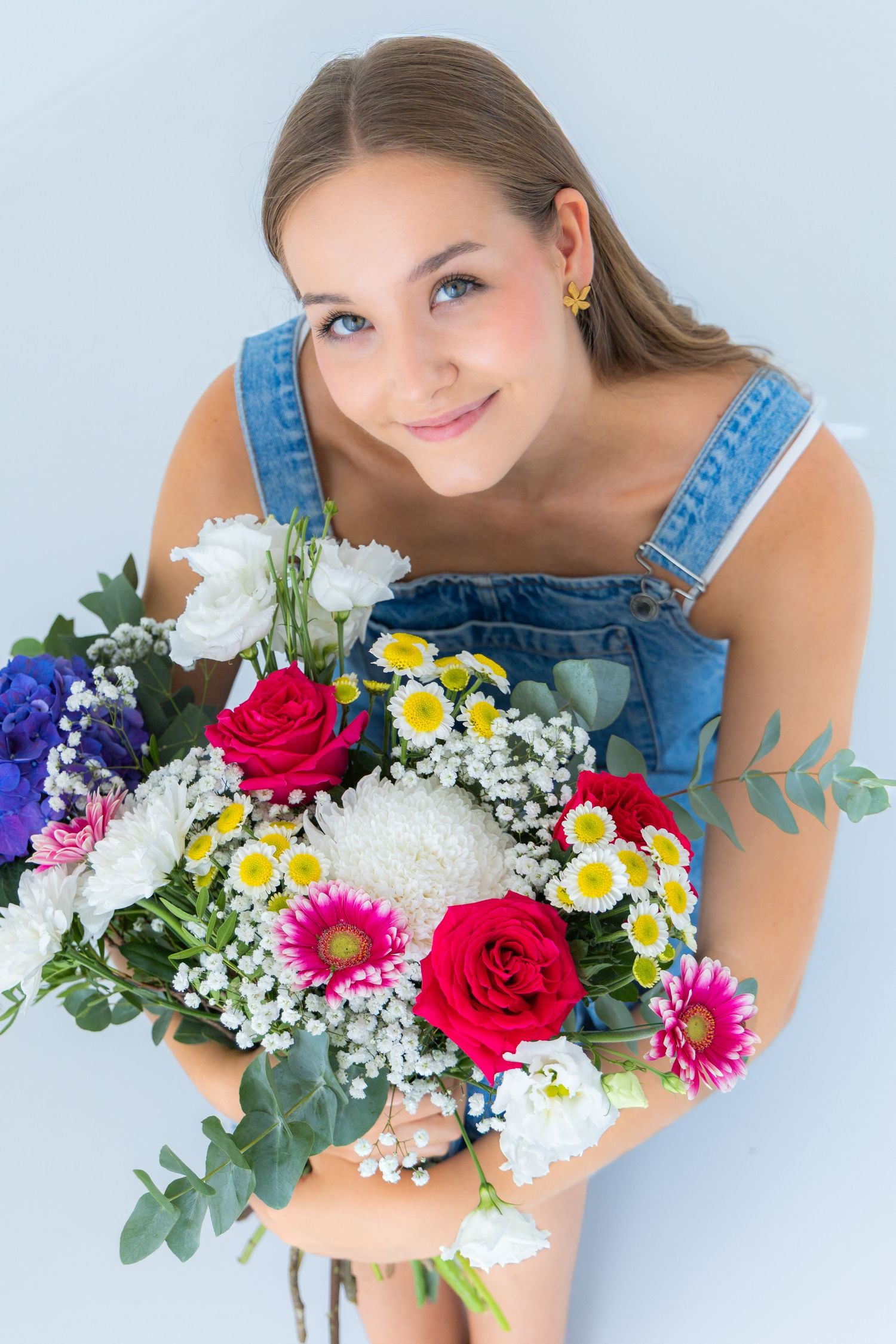 Retrato de una joven rubia sonriendo con ramo de flores en mini sesión en Valdemoro, zona sur de Madrid. Fotografía natural y emocional