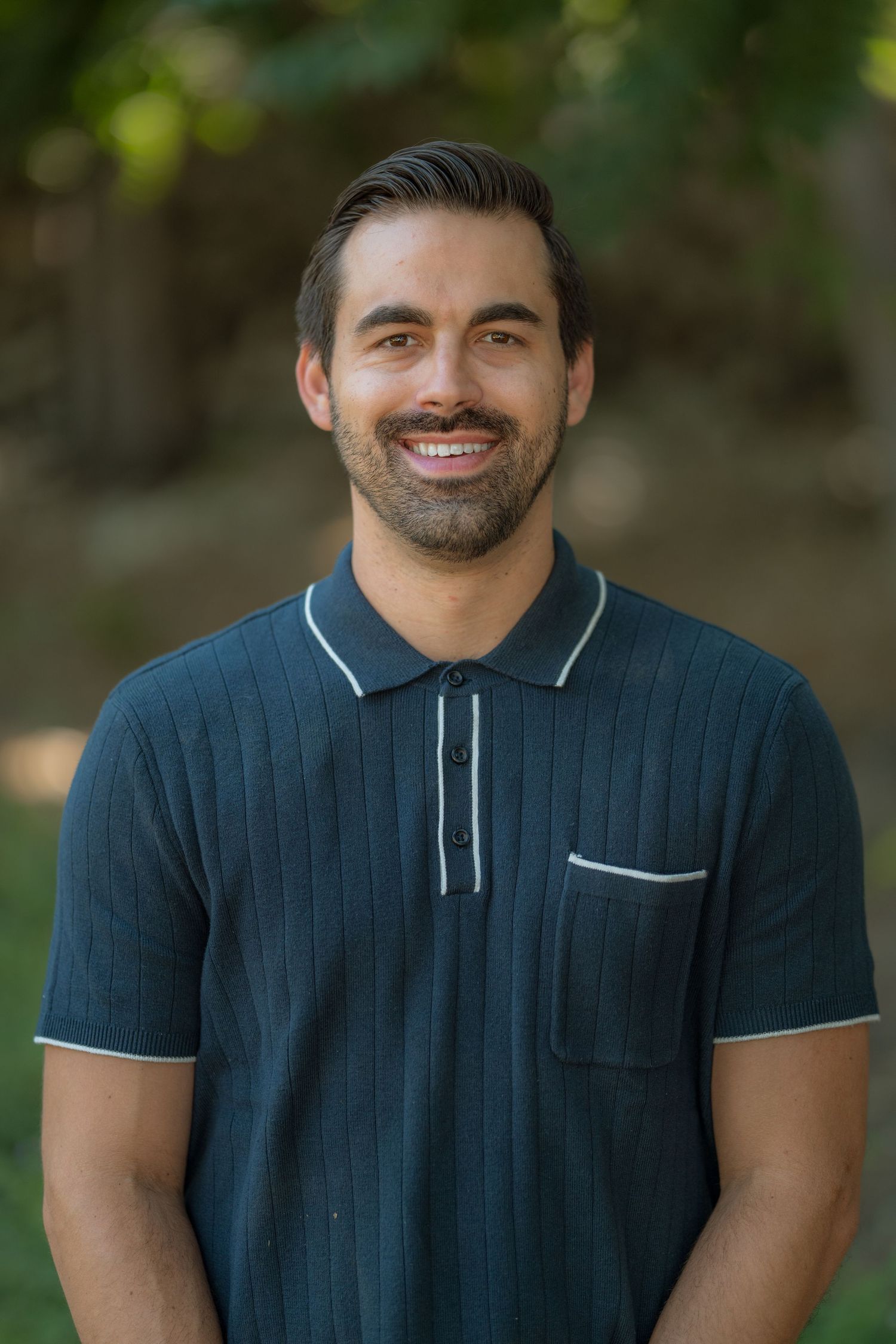 Series of shots showing person in navy polo shirt with white trim against natural background.