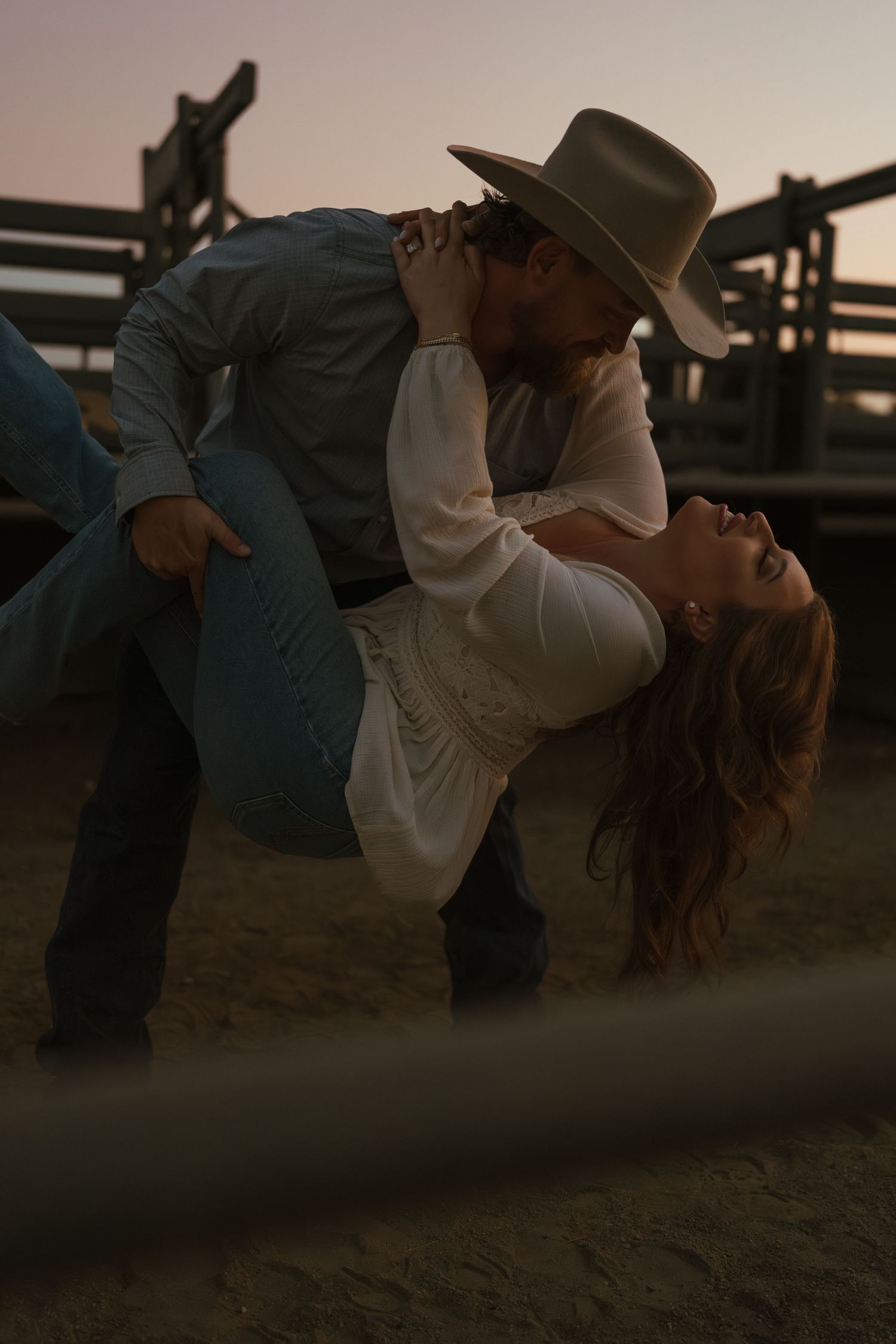 Warm cinematic portrait of a couple embracing in tall grass rolling hills at sunset in the country by Vince Shewmaker.