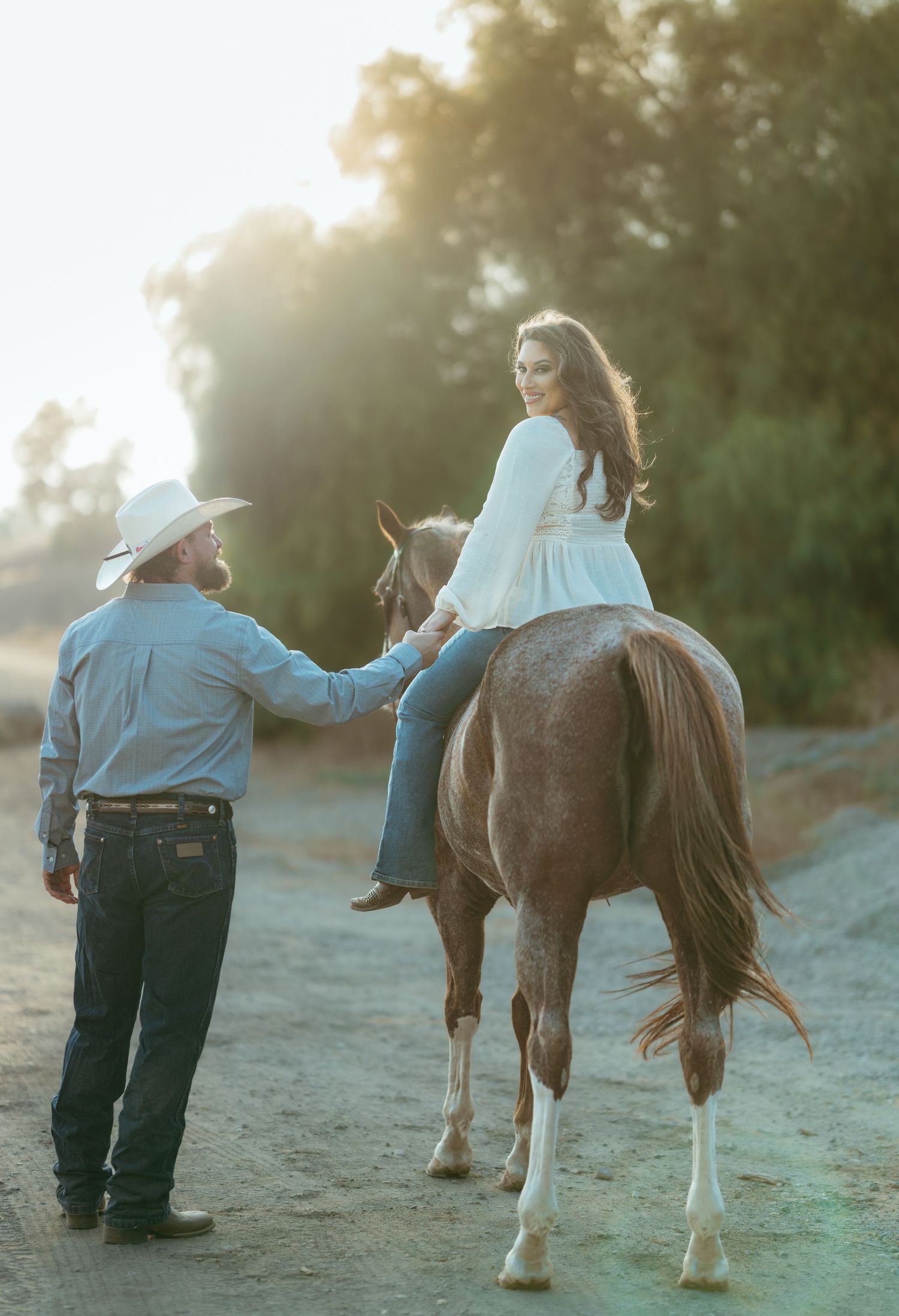Warm cinematic portrait of a couple embracing in tall grass rolling hills at sunset in the country by Vince Shewmaker.