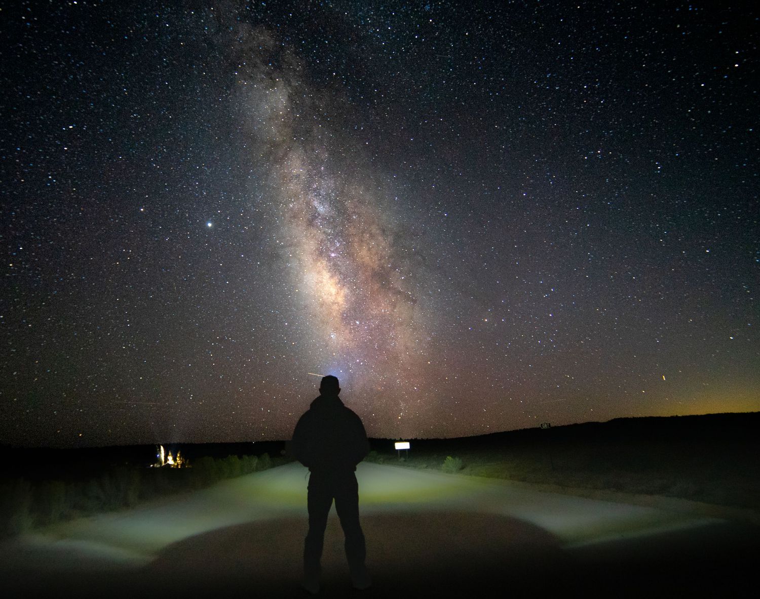 Dramatic wide-angle nature photograph of majestic mountains and stars under a moody sky by Vince Shewmaker.