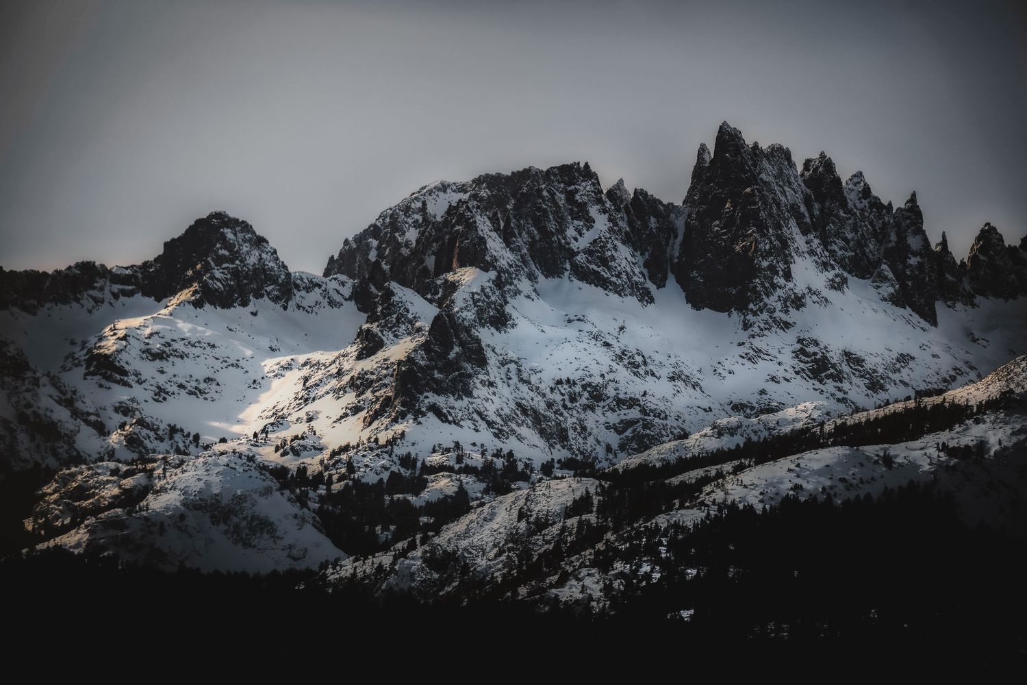 Dramatic wide-angle nature photograph of majestic mountains and stars under a moody sky by Vince Shewmaker.