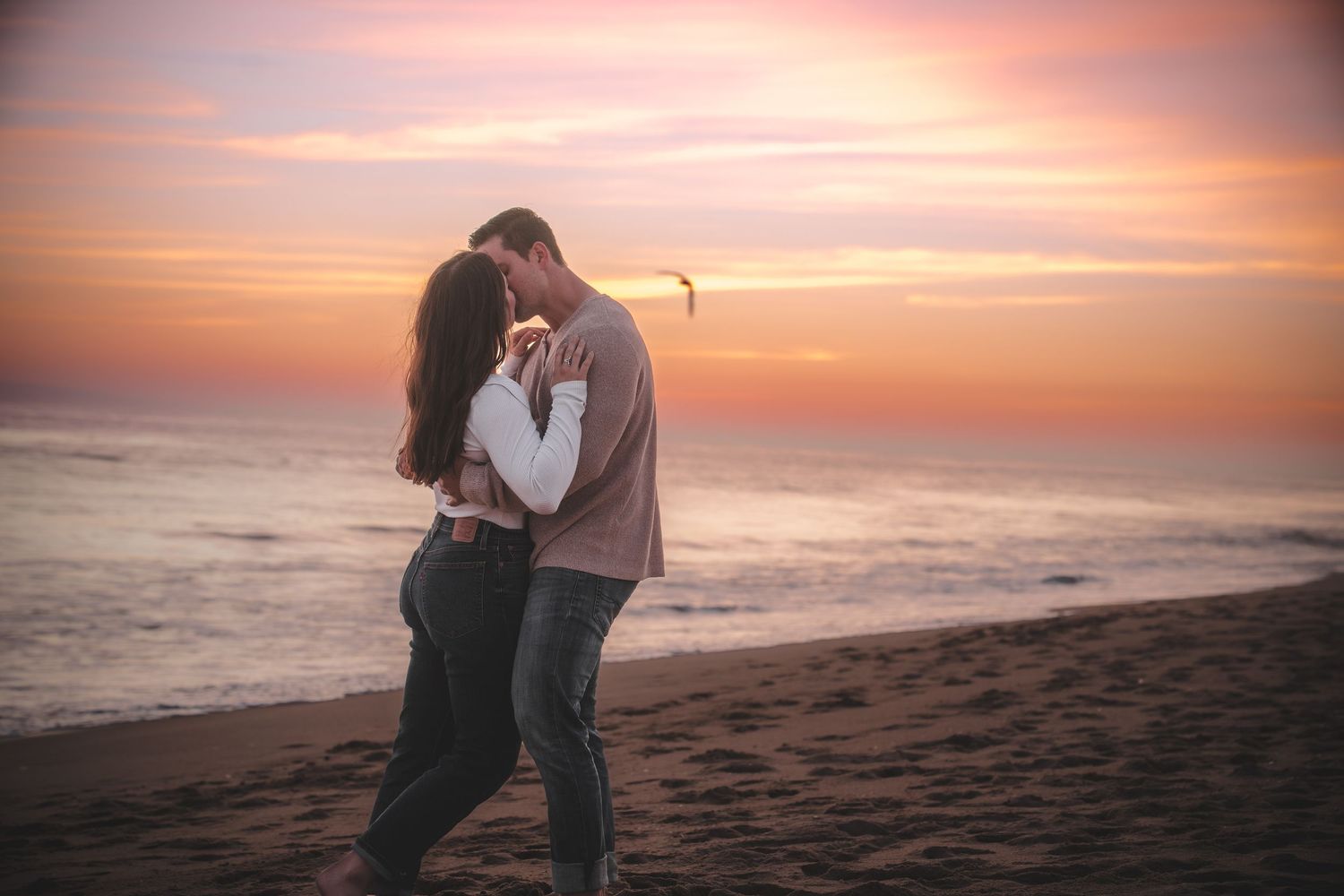 Moody and intimate portrait of a couple holding each other close in a natural outdoor setting with dramatic lighting by Vince Shewmaker.