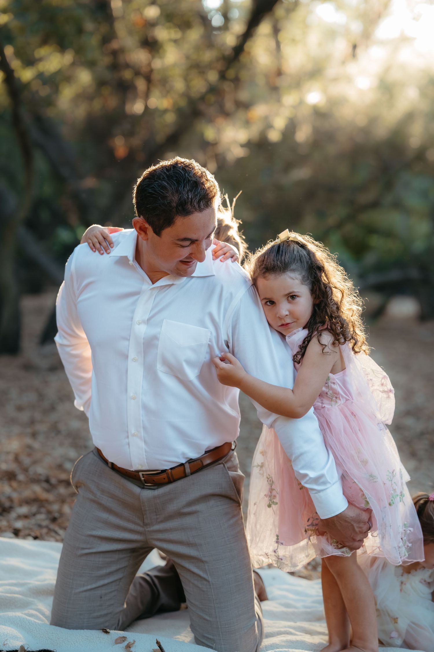 Warm golden hour environmental portrait of a family with children playing in a sunlit field in Southern California by Vince Shewmaker.