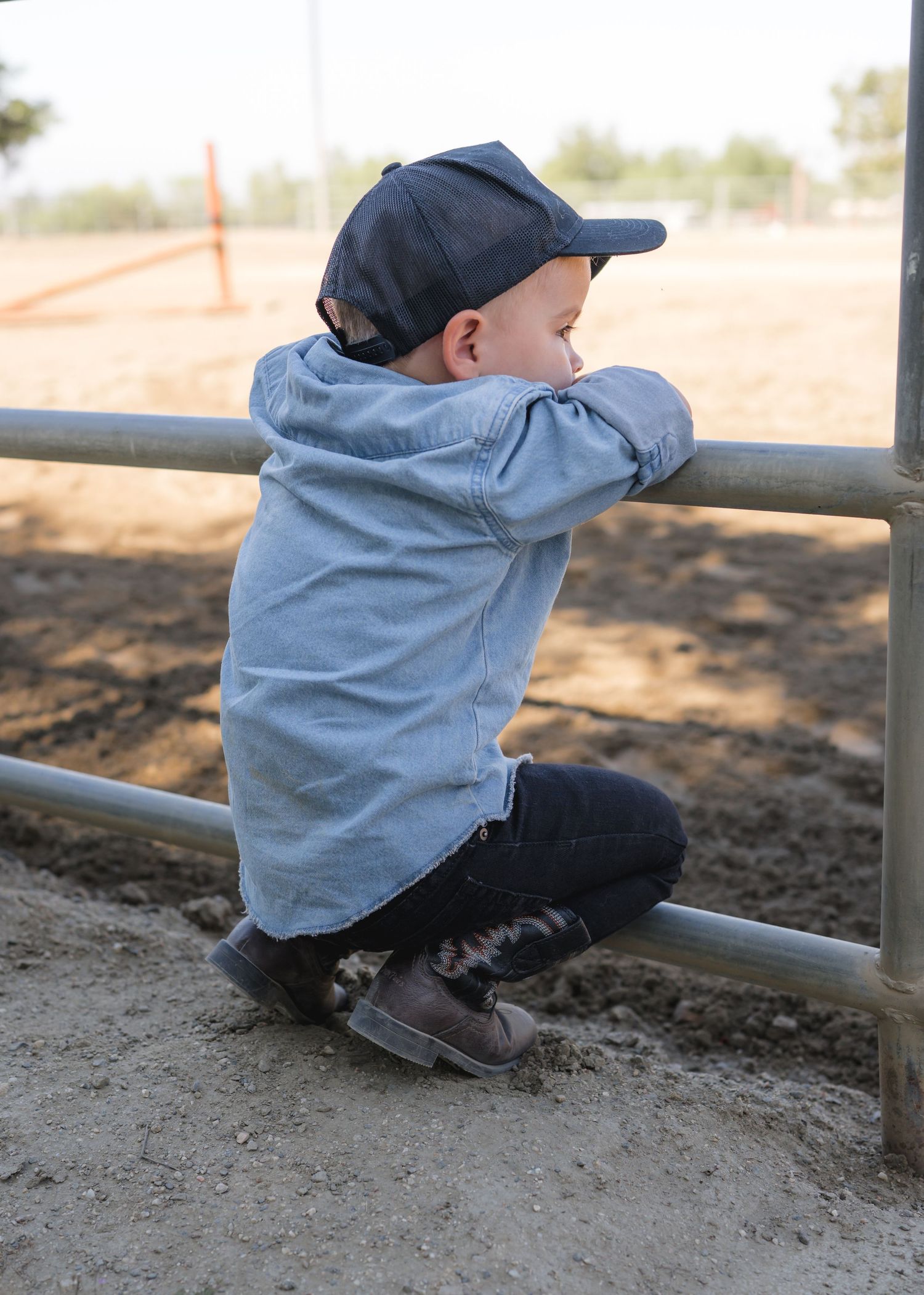 Candid environmental portrait of a young child playing in a natural outdoor setting with soft lighting by Vince Shewmaker.