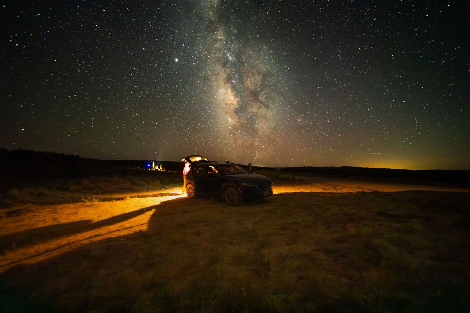 Dramatic wide-angle nature photograph of majestic mountains and stars under a moody sky by Vince Shewmaker.