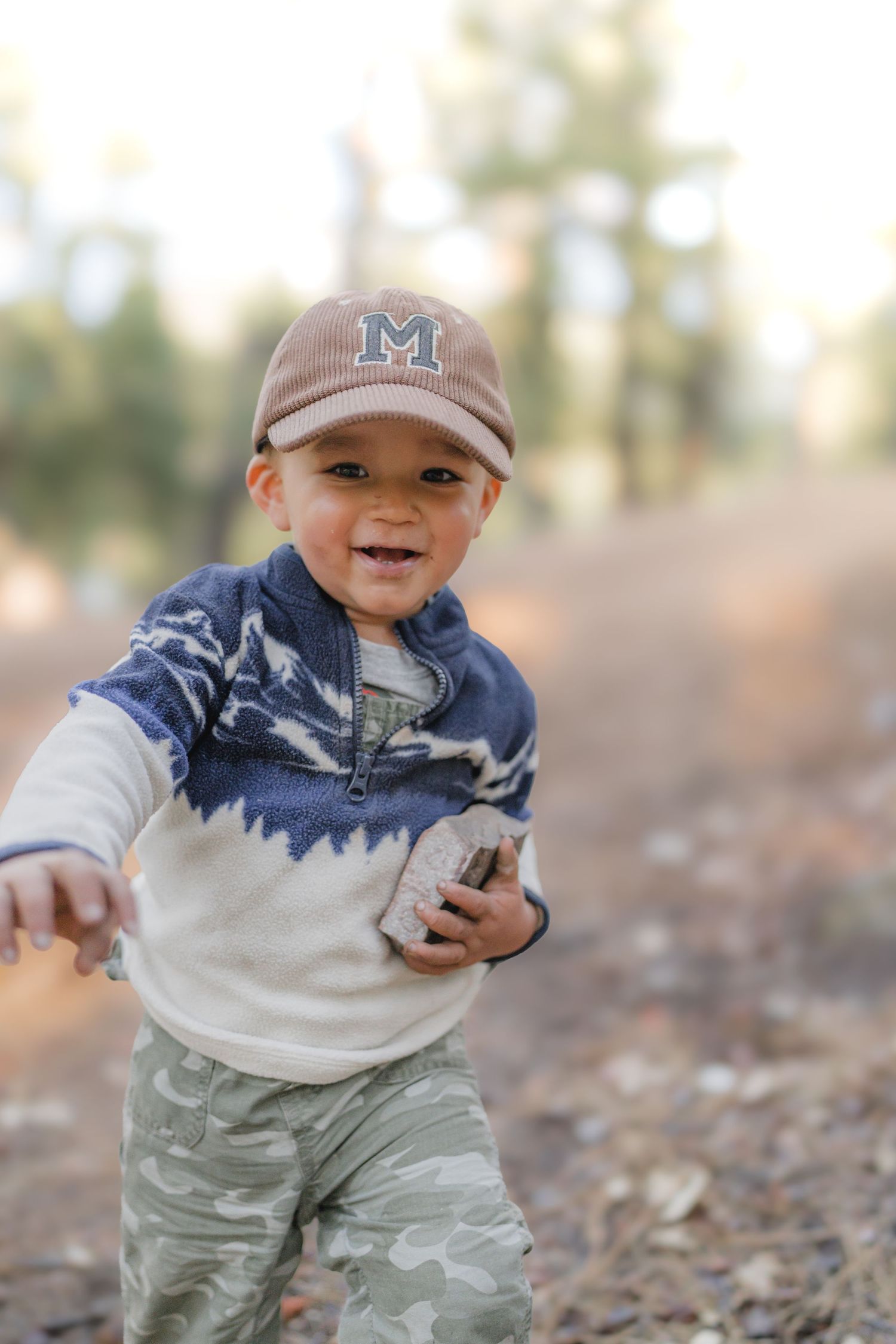 Candid environmental portrait of a young child playing in a natural outdoor setting with soft lighting by Vince Shewmaker.