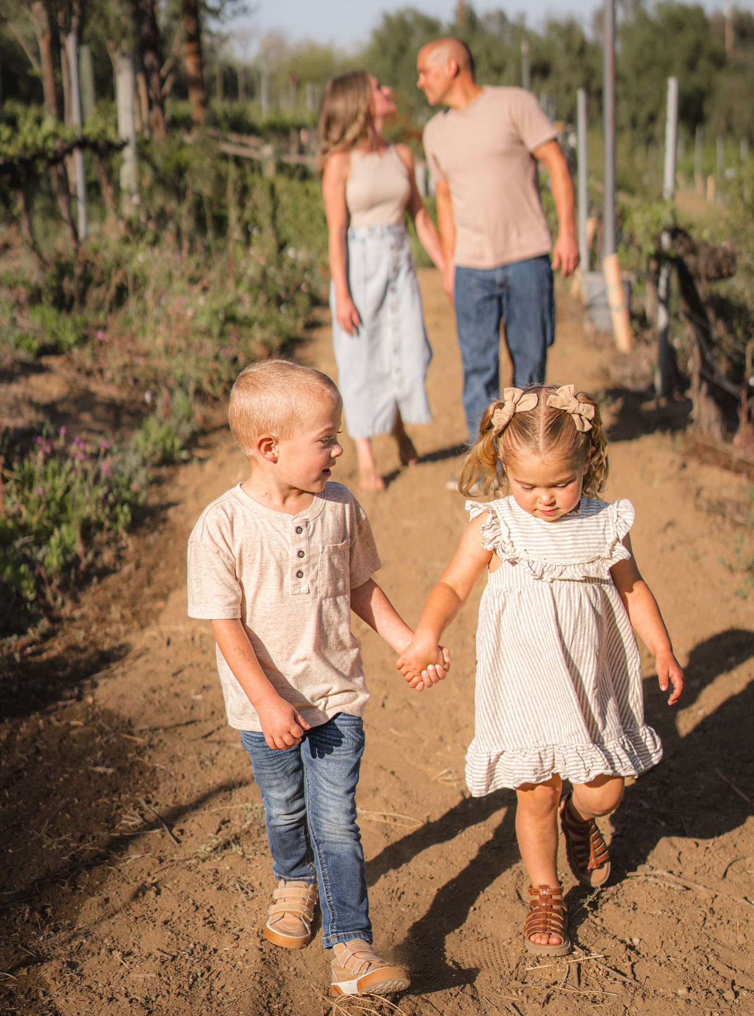 Warm golden hour environmental portrait of a family with children playing in a sunlit field in Southern California by Vince Shewmaker.