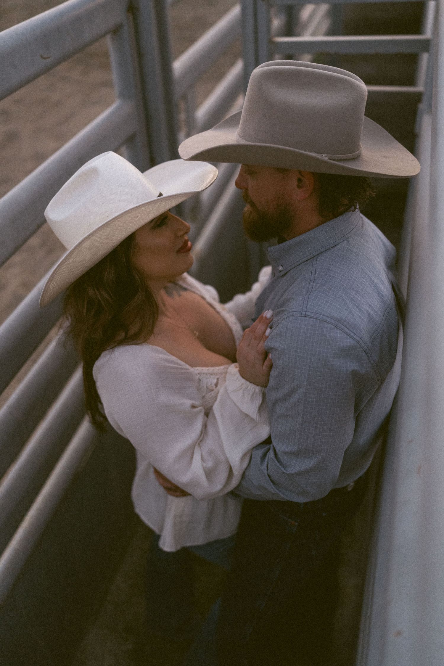 Warm cinematic portrait of a couple embracing in tall grass rolling hills at sunset in the country by Vince Shewmaker.
