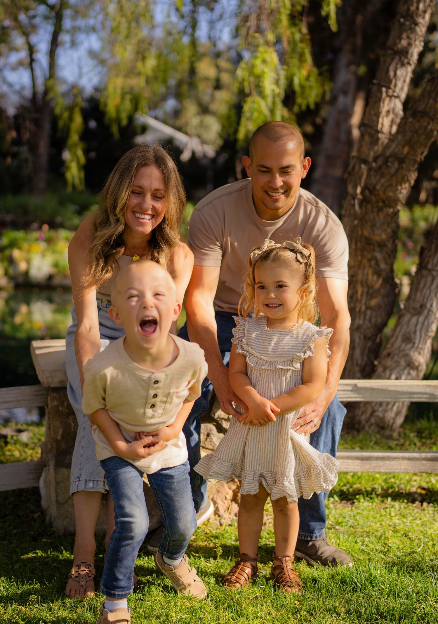 Warm golden hour environmental portrait of a family with children playing in a sunlit field in Southern California by Vince Shewmaker.