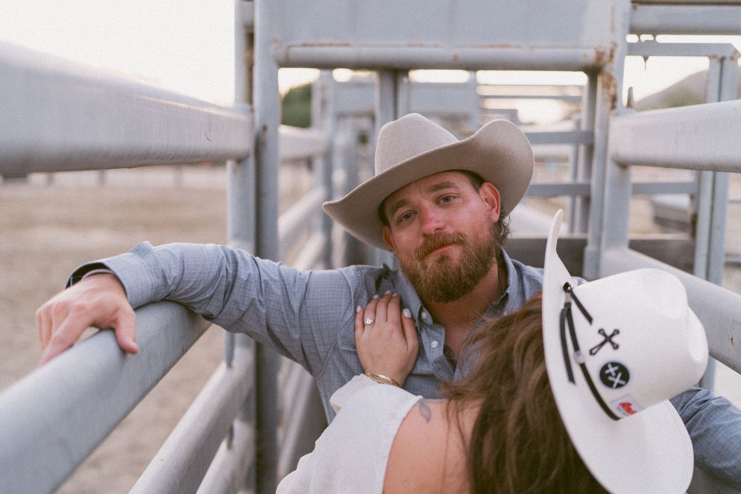 Warm cinematic portrait of a couple embracing in tall grass rolling hills at sunset in the country by Vince Shewmaker.