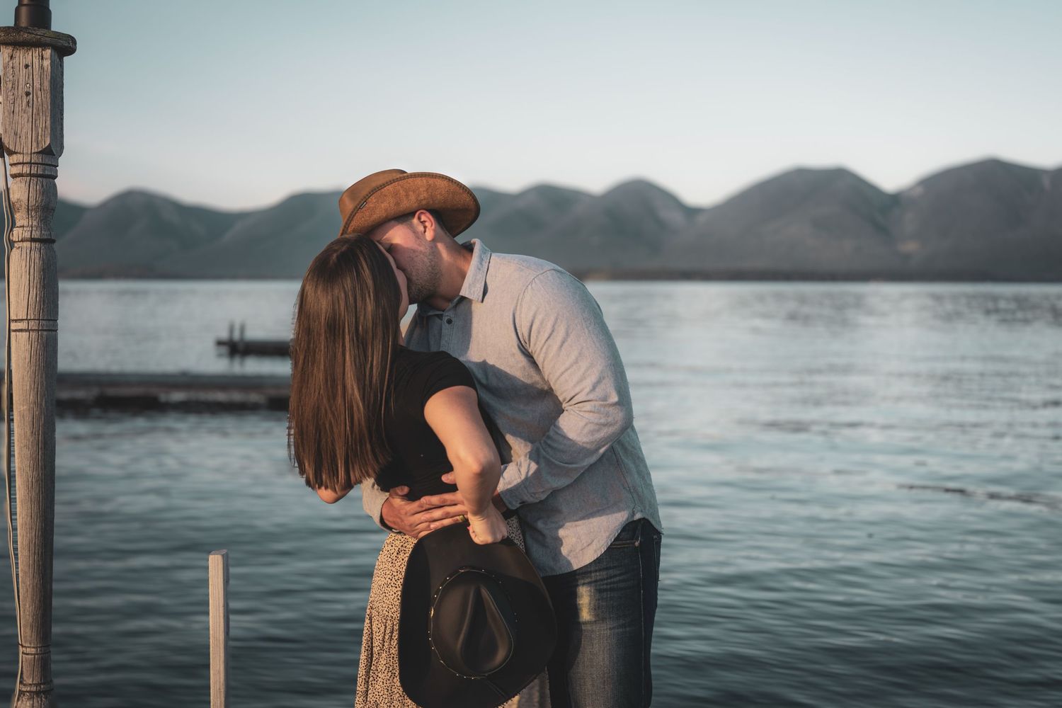 Moody and intimate portrait of a couple holding each other close in a natural outdoor setting with dramatic lighting by Vince Shewmaker.