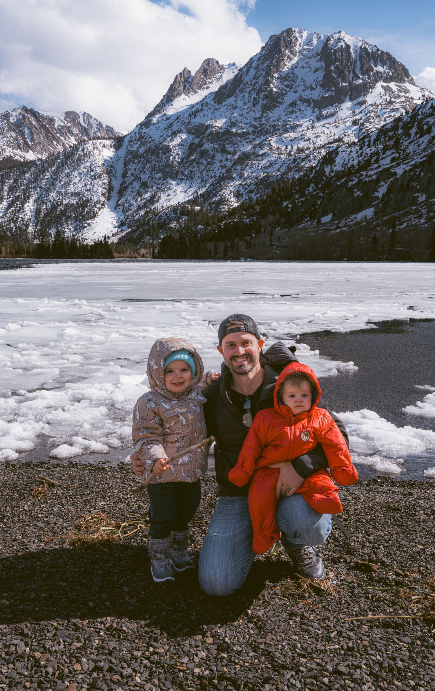 Cinematic outdoor portrait of a family standing together in a rustic natural landscape by Vince Shewmaker.
