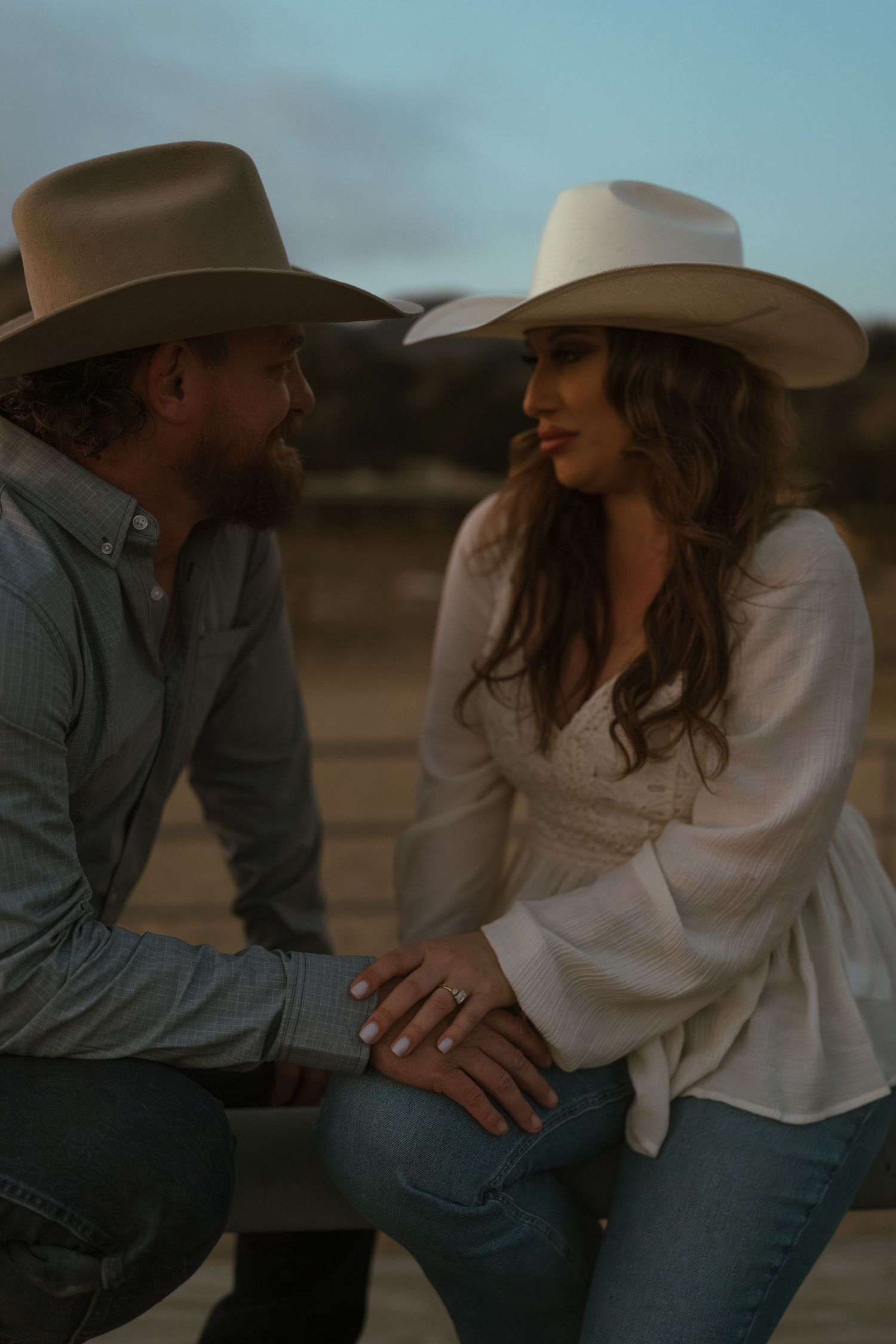 Warm cinematic portrait of a couple embracing in tall grass rolling hills at sunset in the country by Vince Shewmaker.