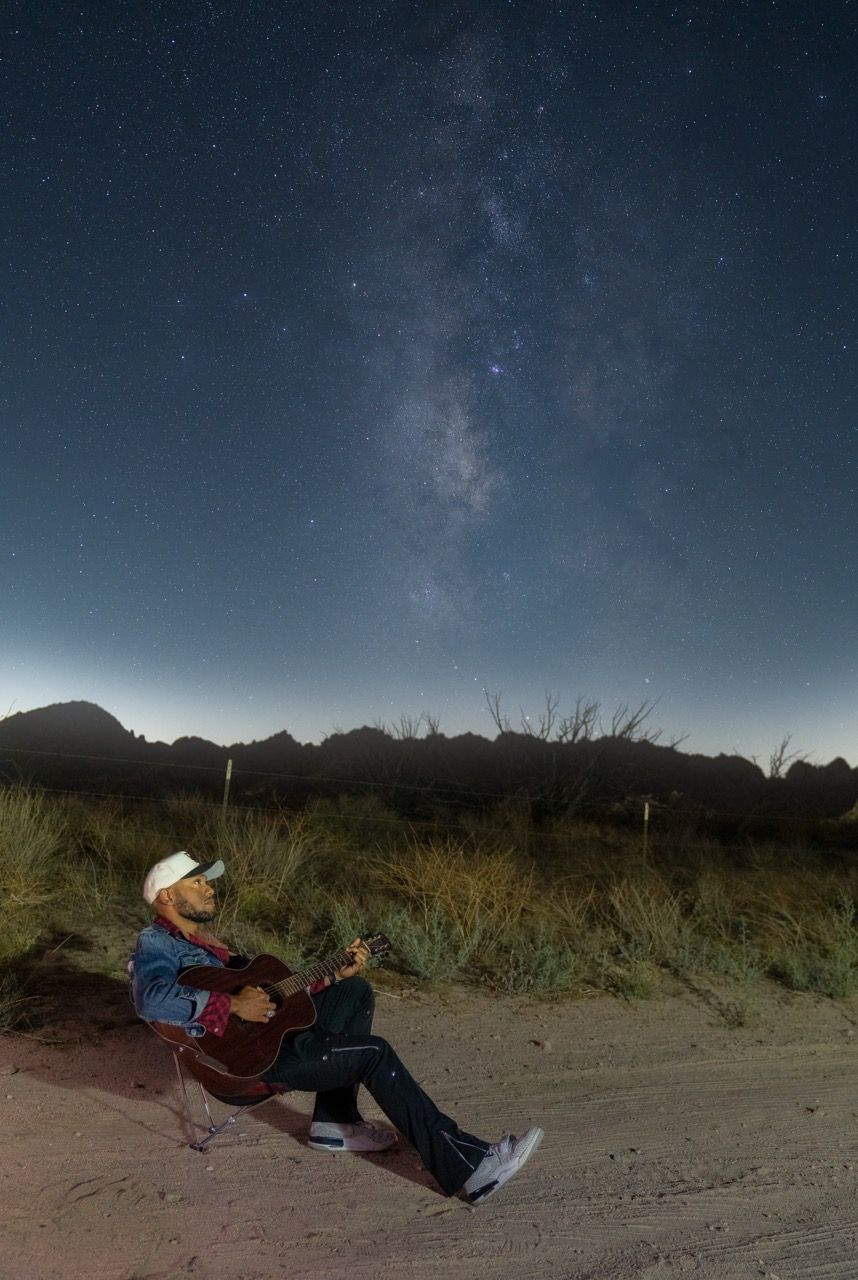 A person appears to be falling backwards in a sequence of photos against a starry night sky in a desert landscape.