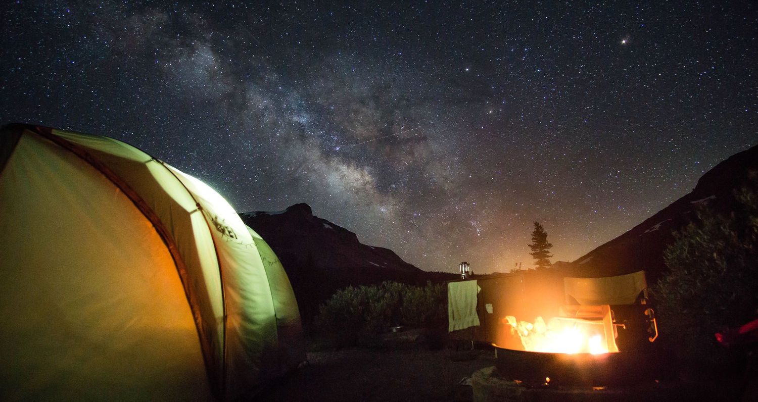 Dramatic wide-angle nature photograph of majestic mountains and stars under a moody sky by Vince Shewmaker.
