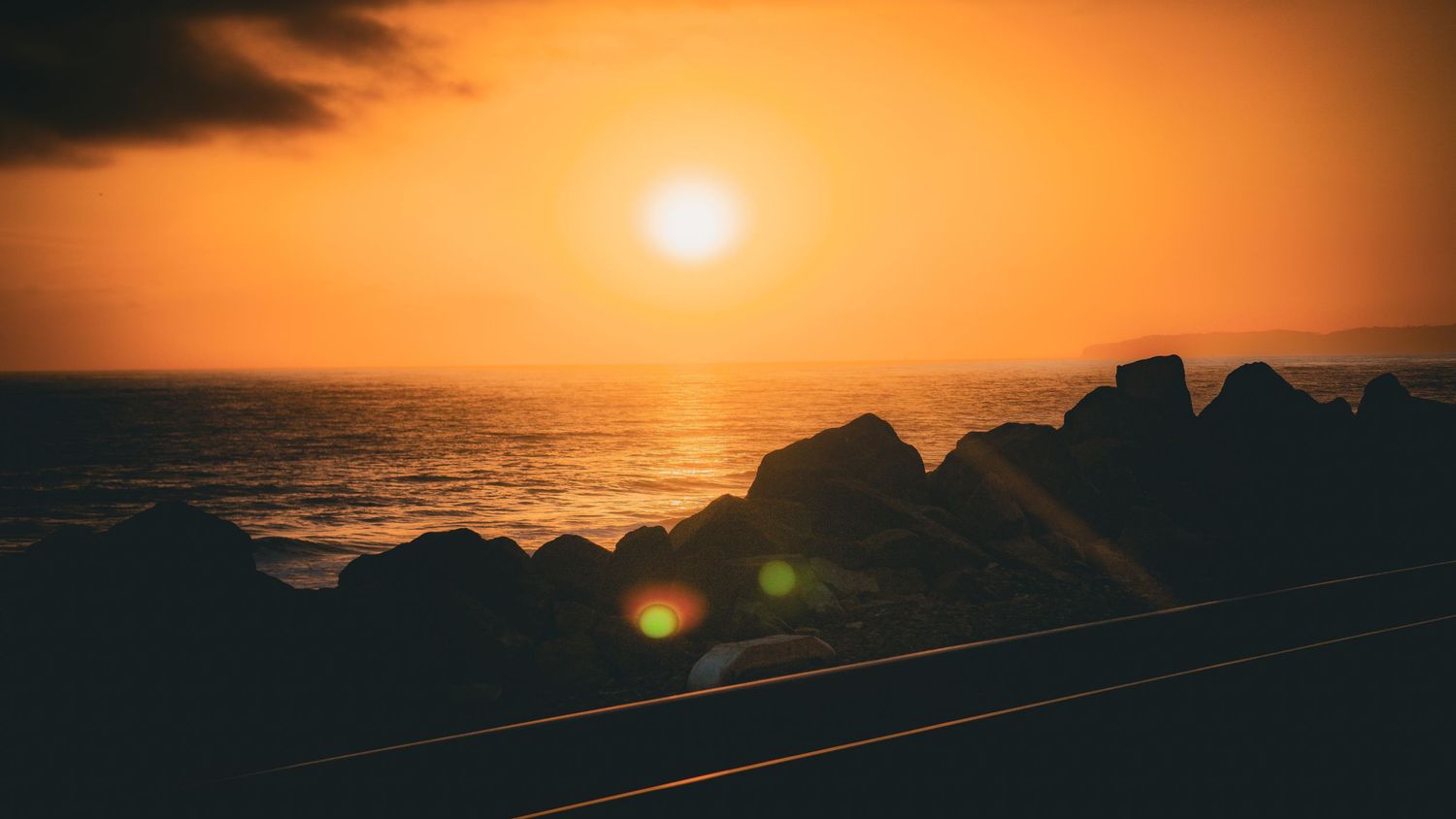 Cinematic landscape photograph of a dramatic sunset over the rocky cliffs and crashing waves of Laguna Beach California by Vince Shewmaker.