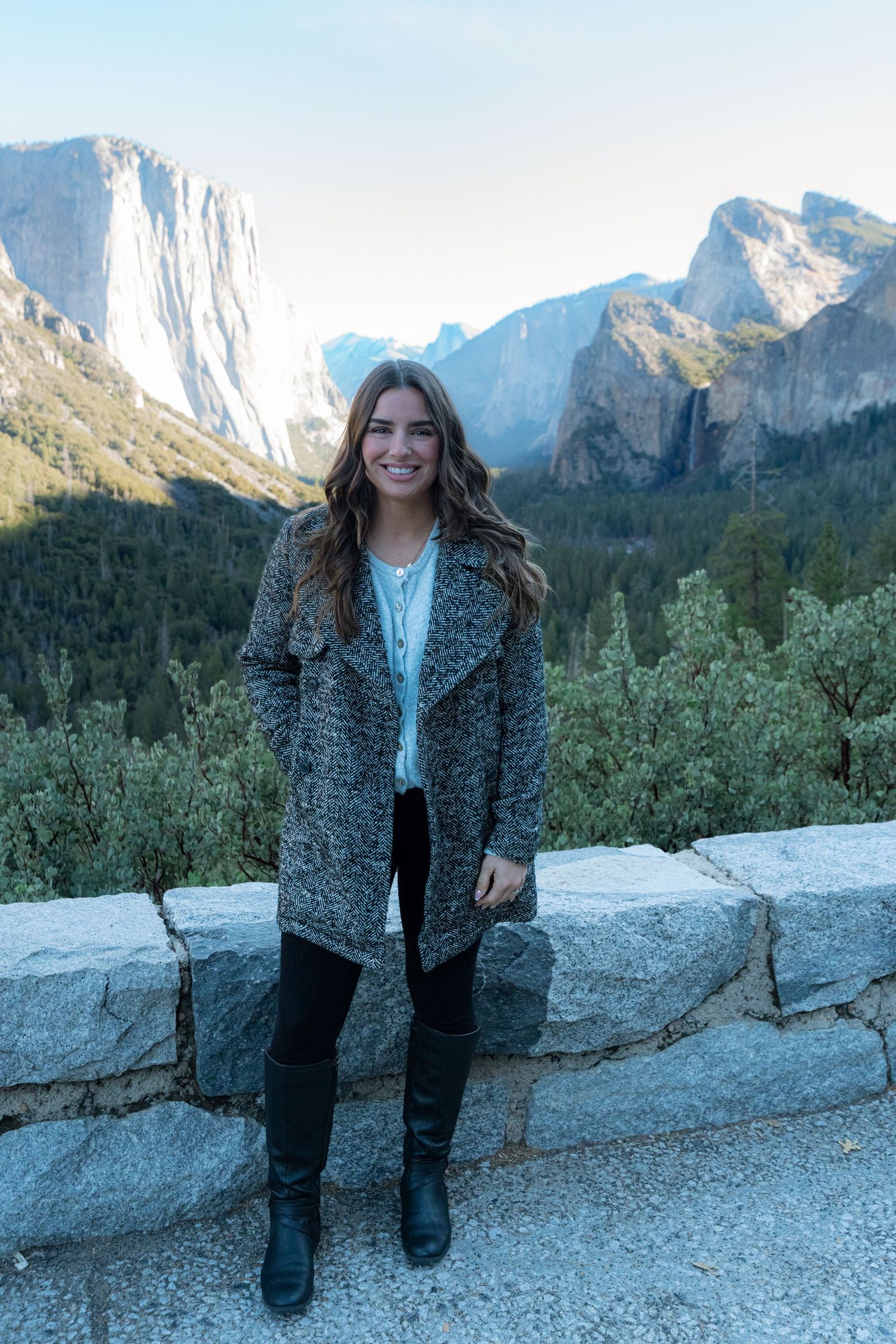 Scenic viewpoint overlooking Yosemite Valley's granite cliffs and mountains on a clear winter day.