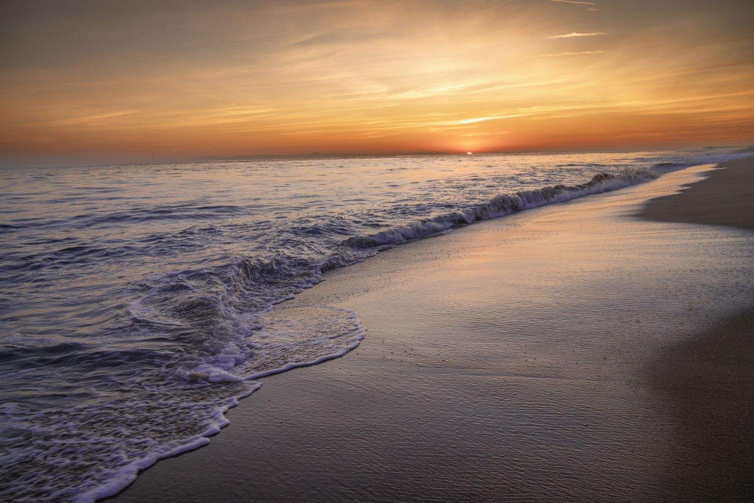 Cinematic landscape photograph of a dramatic sunset over the rocky cliffs and crashing waves of Laguna Beach California by Vince Shewmaker.