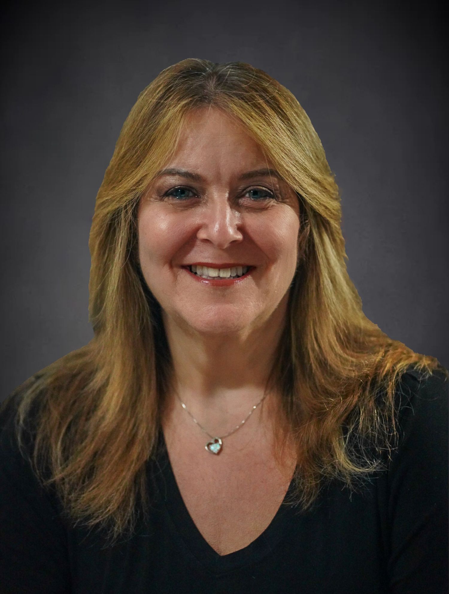 headshot of woman with brown hair and highlights in grey background and black shirt.