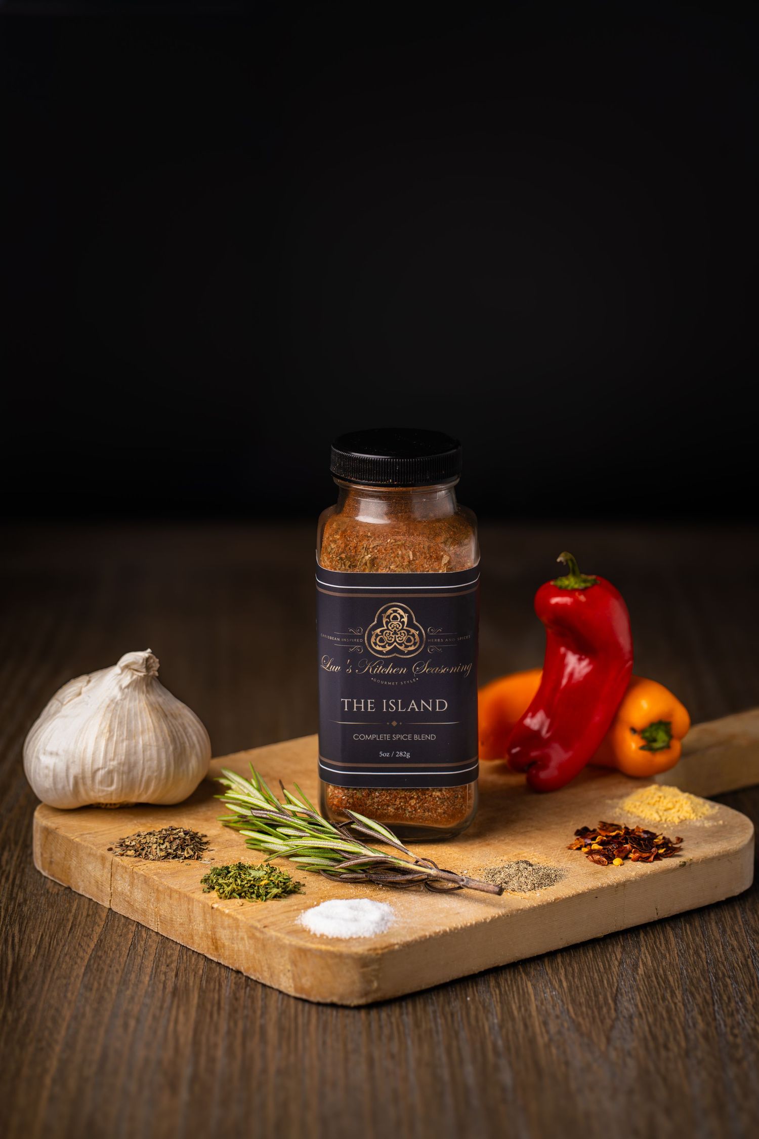 Food photography with black background. Cutting board with spice jar with raw herbs and spices in natural form on board.