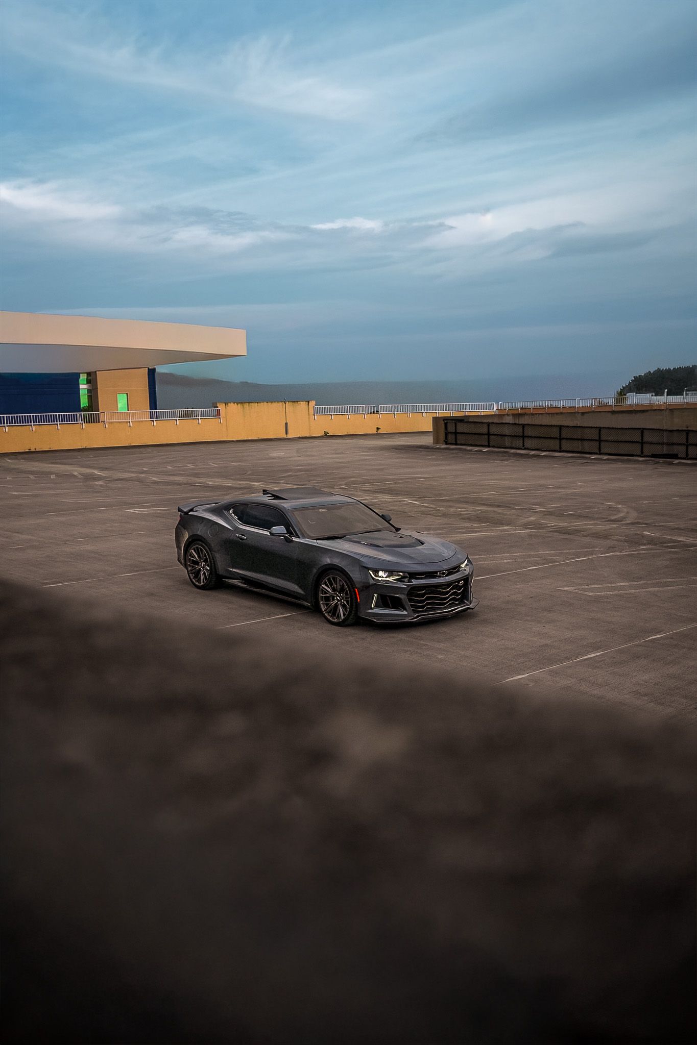 ZL1 Camaro automotive photoshoot on garage top with sky in background.