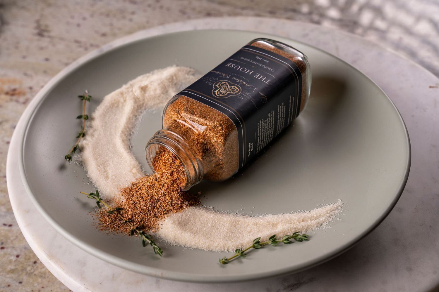 Spice jar and spices splayed out in dish. Product photography
