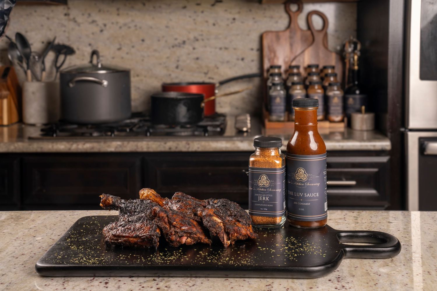 Product photography. Spices and sauce in bottles displayed in kitchen with black cutting board that has barbequed chicken on it.