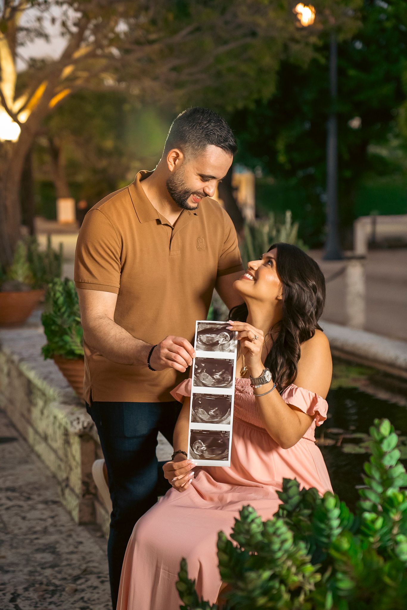 Maternity photograph. Husband and wife holding up a printout of their sonogram in West Palm Beach, Lake worth, Boynton Beach, Florida.