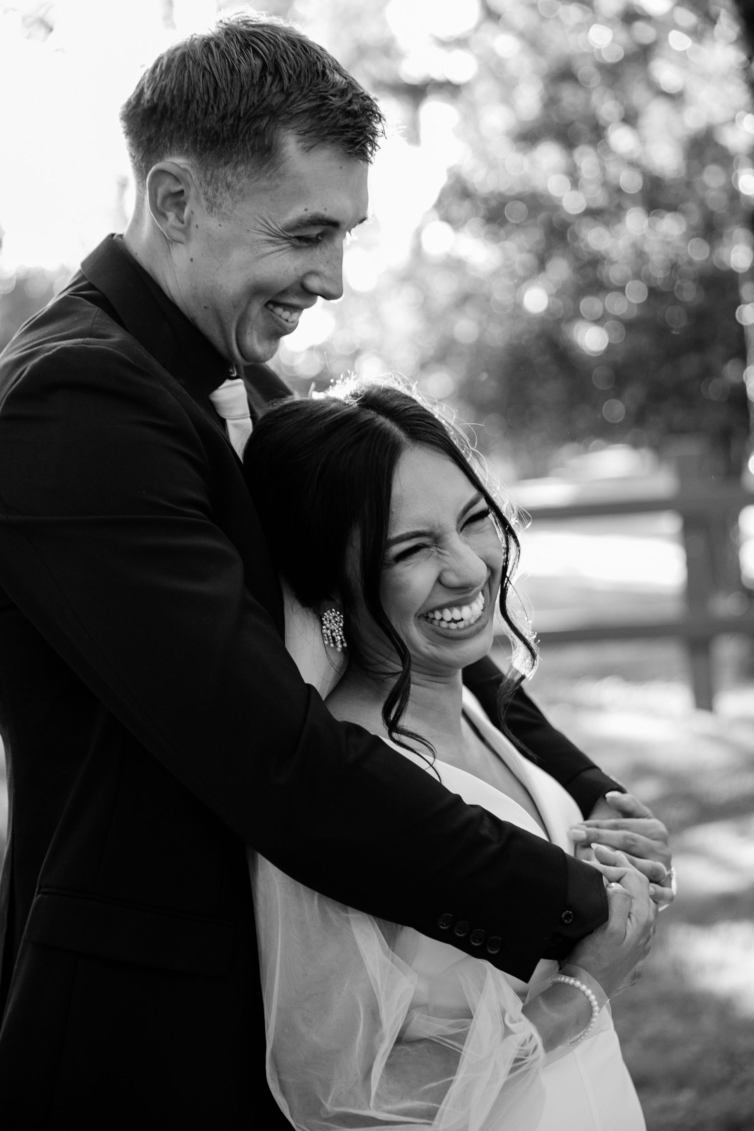 A joyful black and white portrait of a couple sharing a candid laughing moment.