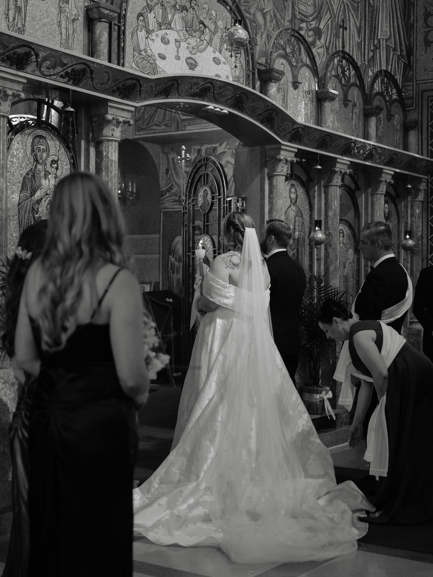 Black and white photo of a bride and groom at the altar during an Orthodox church wedding ceremony.