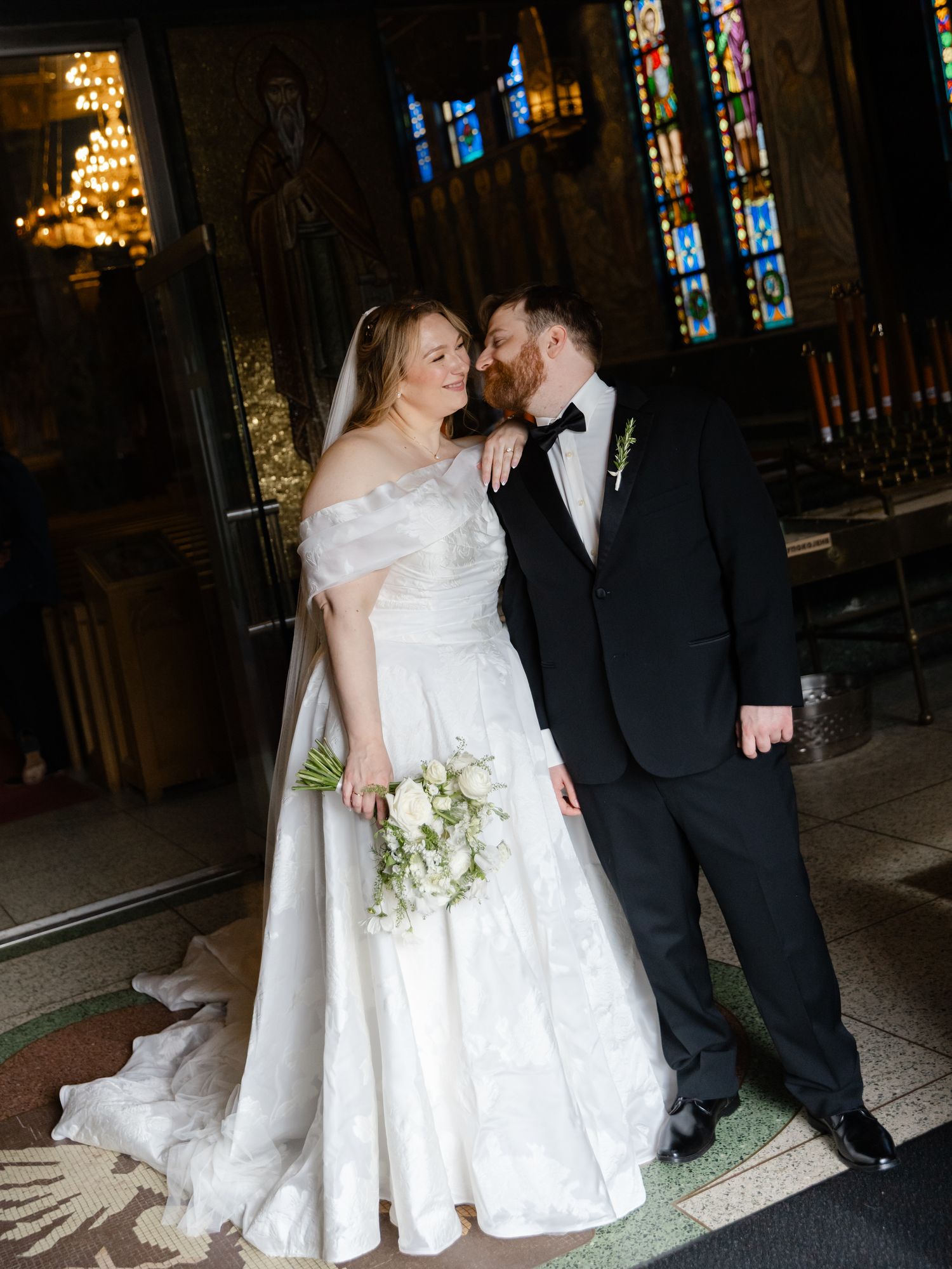 Bride and groom share a romantic moment inside an ornate Byzantine church after their wedding ceremony.