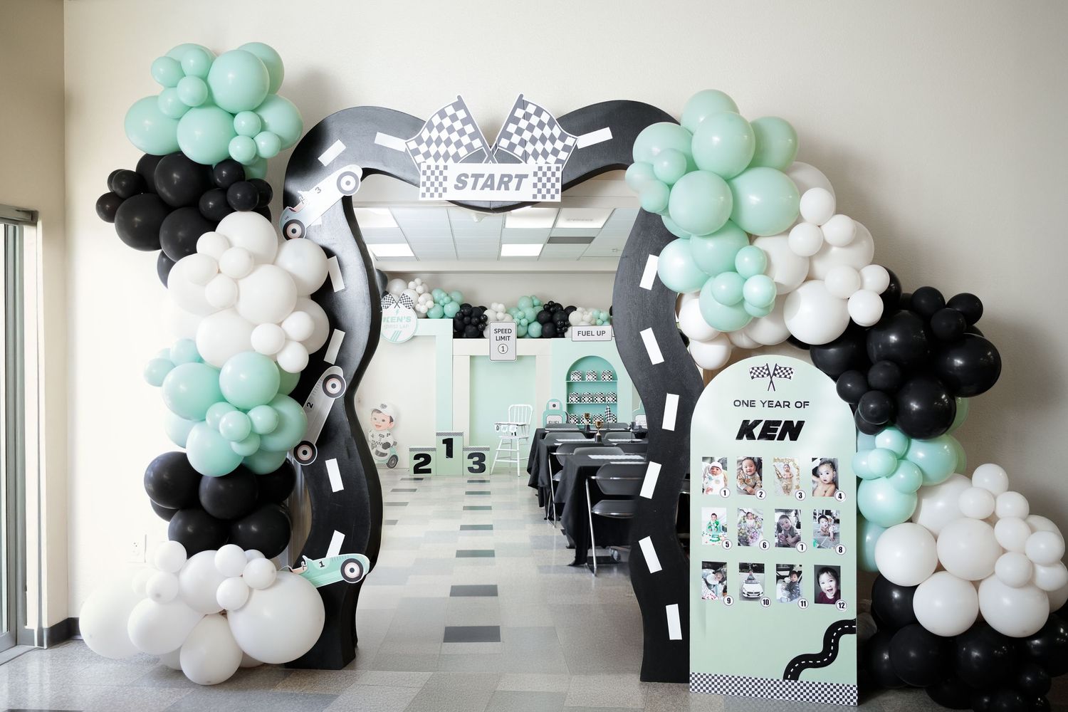 Balloon garland decorations in mint green, black and white colors line the walls of a modern office space.