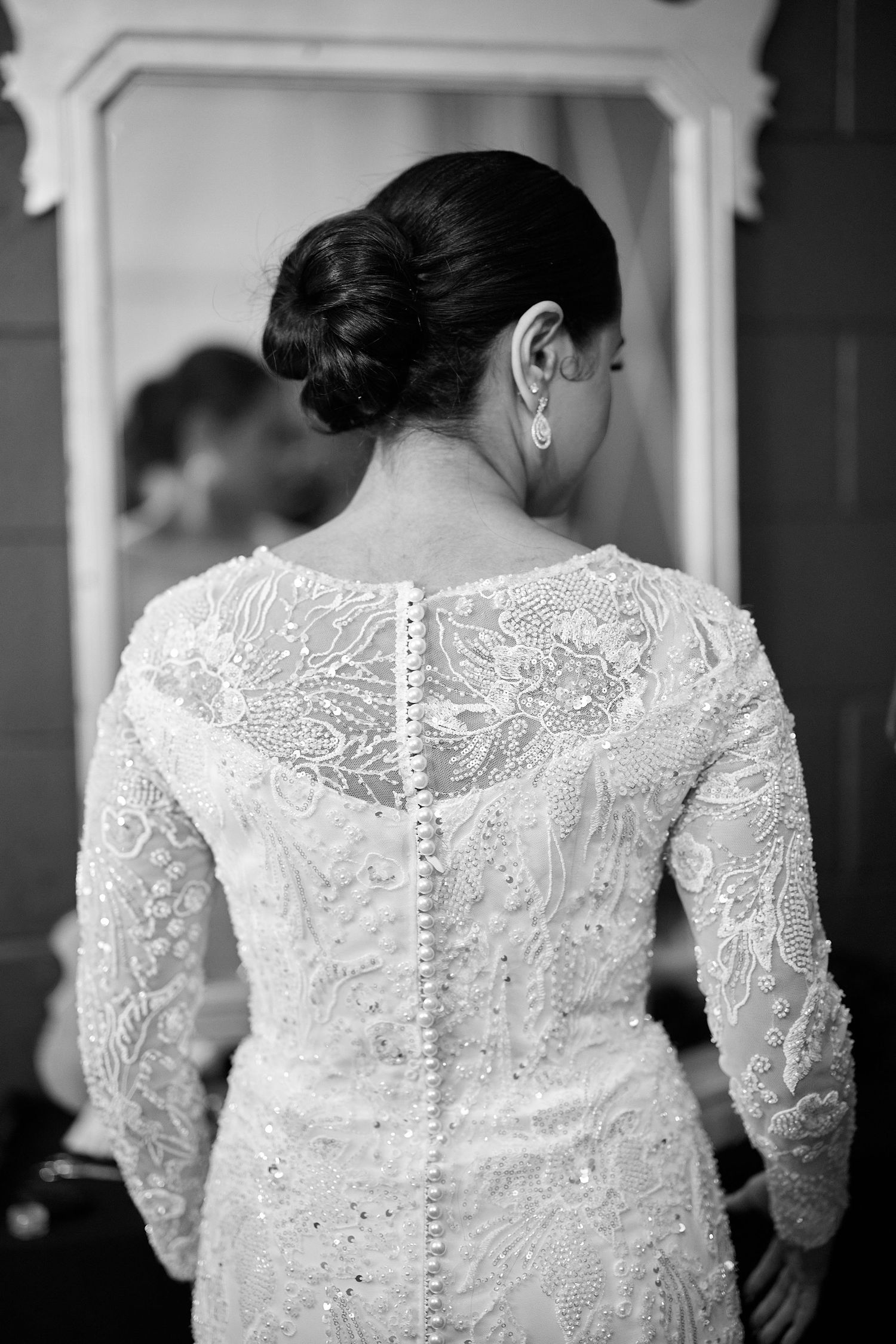 Back view of intricate lace wedding dress with button details and delicate embroidery.