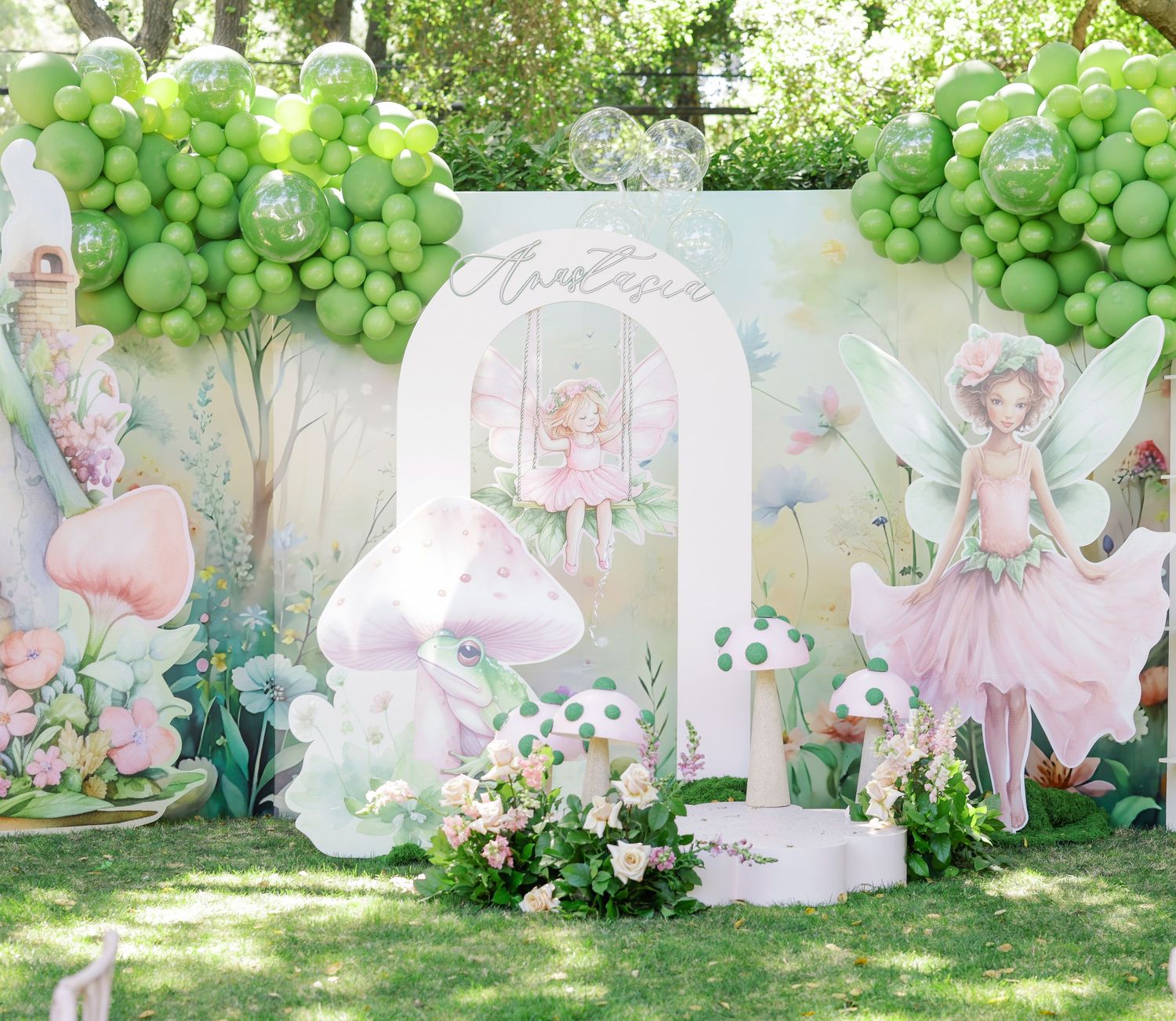 Fairy-themed garden party decoration with pastel balloons and butterfly motifs.