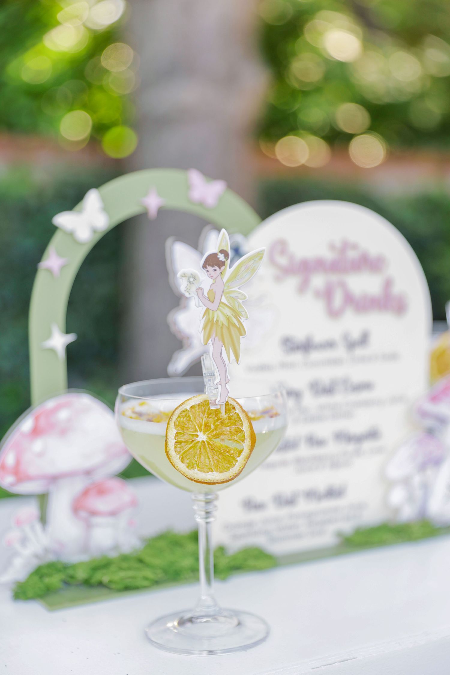 Decorative drink menu cards featuring fairy illustrations and citrus garnish designs.