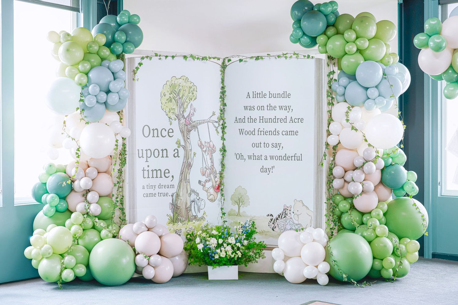 Modern event space decorated with gorgeous green and white balloon arch installations.