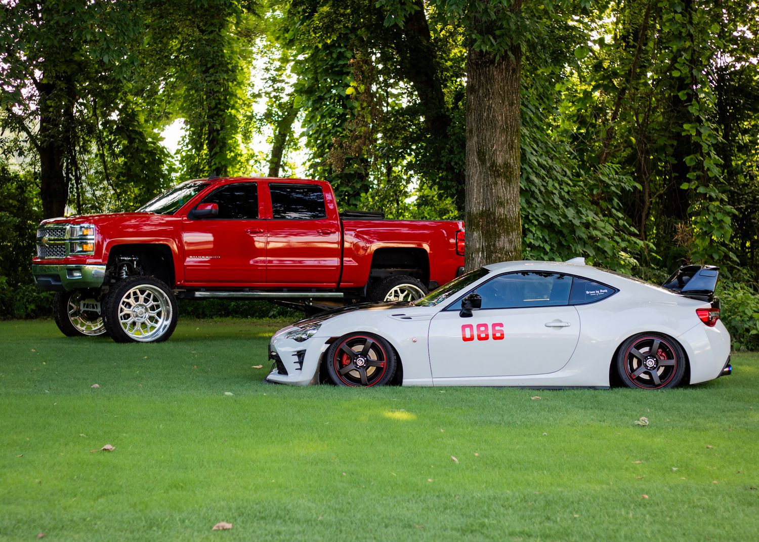 Lifted Chevy Silverado LT and lowered GT86 in the grass
