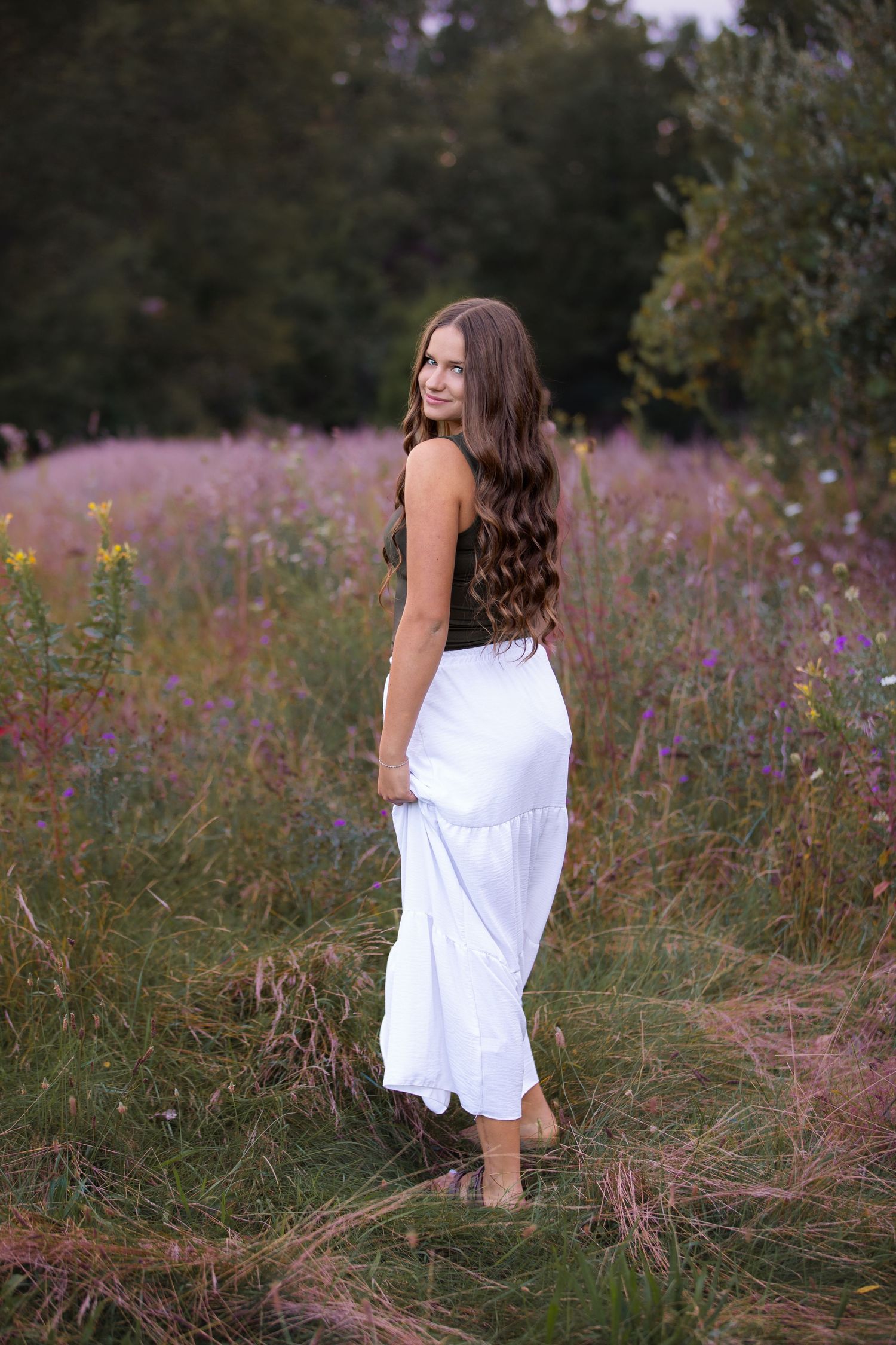 High school senior girl at sunset portrait session in field of wild flowers in South Lyon, Michigan by Brighton, MI photographer
