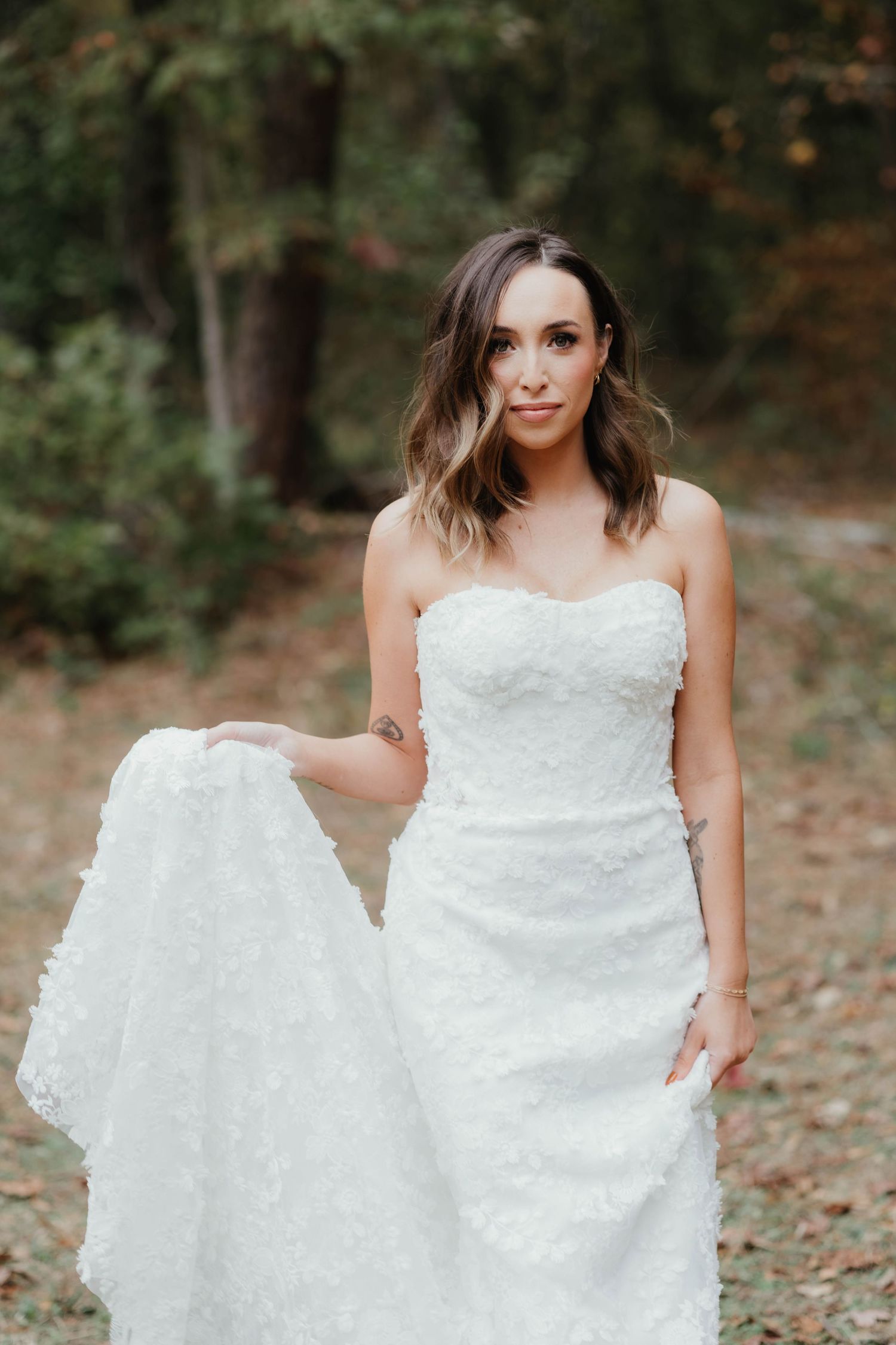 A bridal photo series shows someone in a white wedding dress posing outdoors among autumn leaves on the ground.
