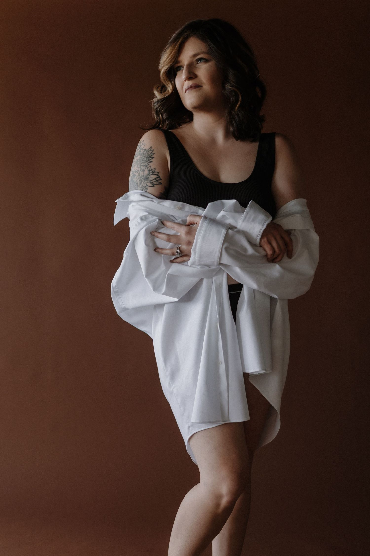Artistic portrait with white button-down shirt in dramatic studio lighting.
