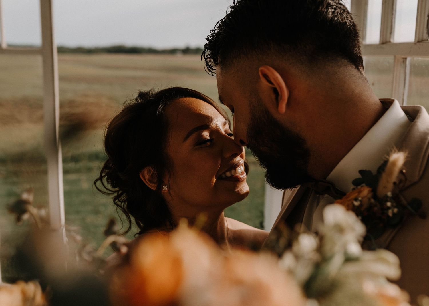 Warm sunset wedding portrait capturing intimate moment between newlyweds.