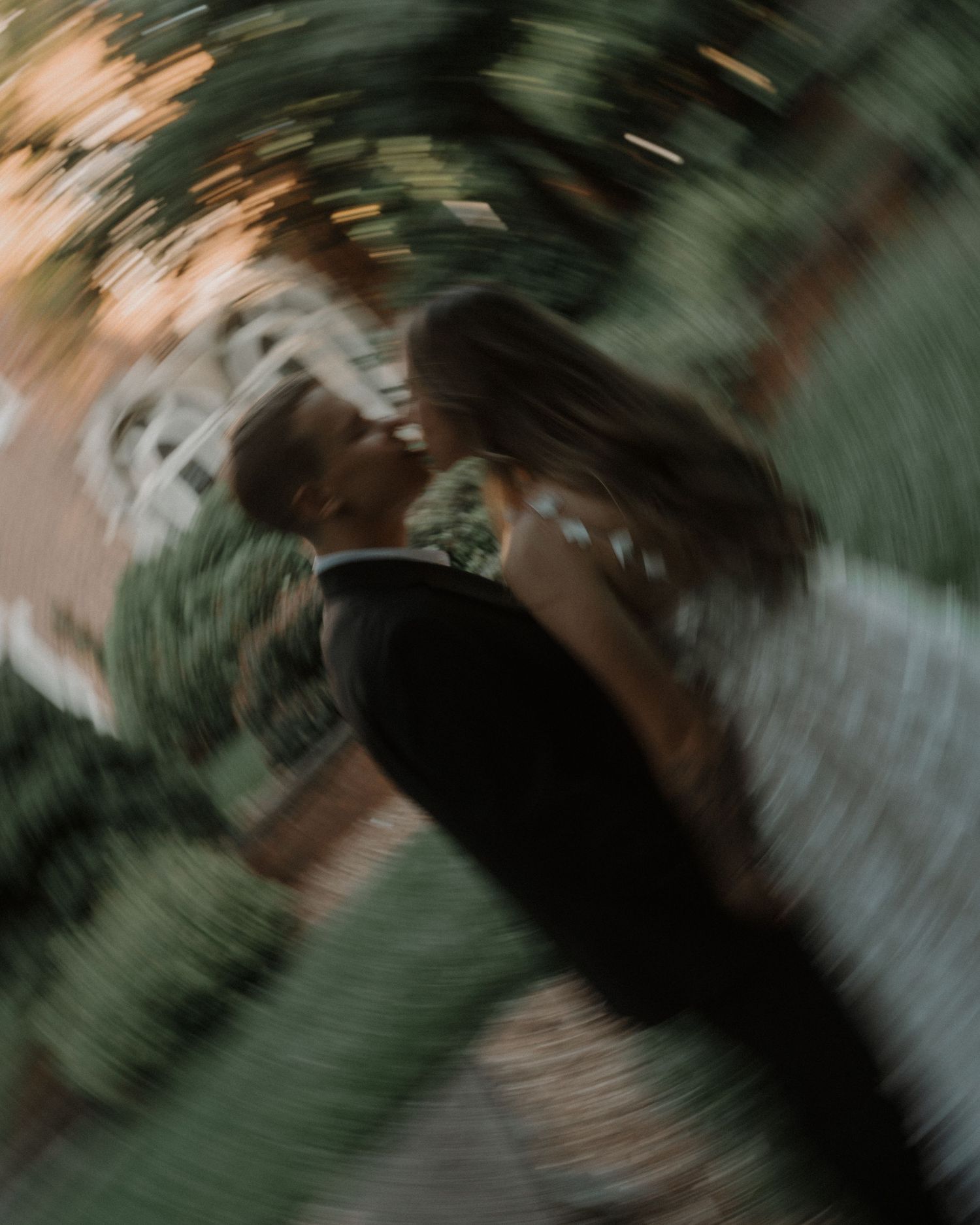 Abstract blurred motion effect creates swirls of dark green and brown tones in an artistic composition.