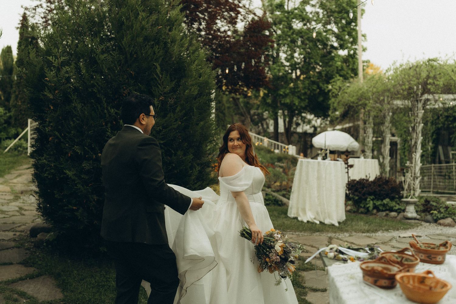 Bride and groom walking through the lush Secret Garden at Sundance wedding venue in Benton Harbor, Michigan.