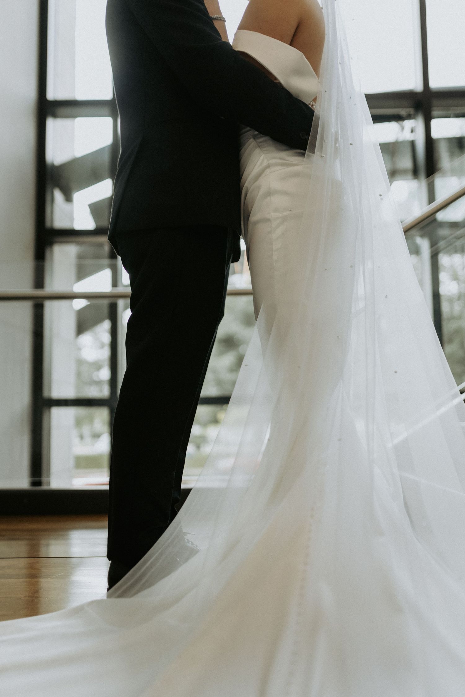 A montage of wedding photos showing the elegant flow of a white bridal gown next to a black tuxedo during formal portraits.