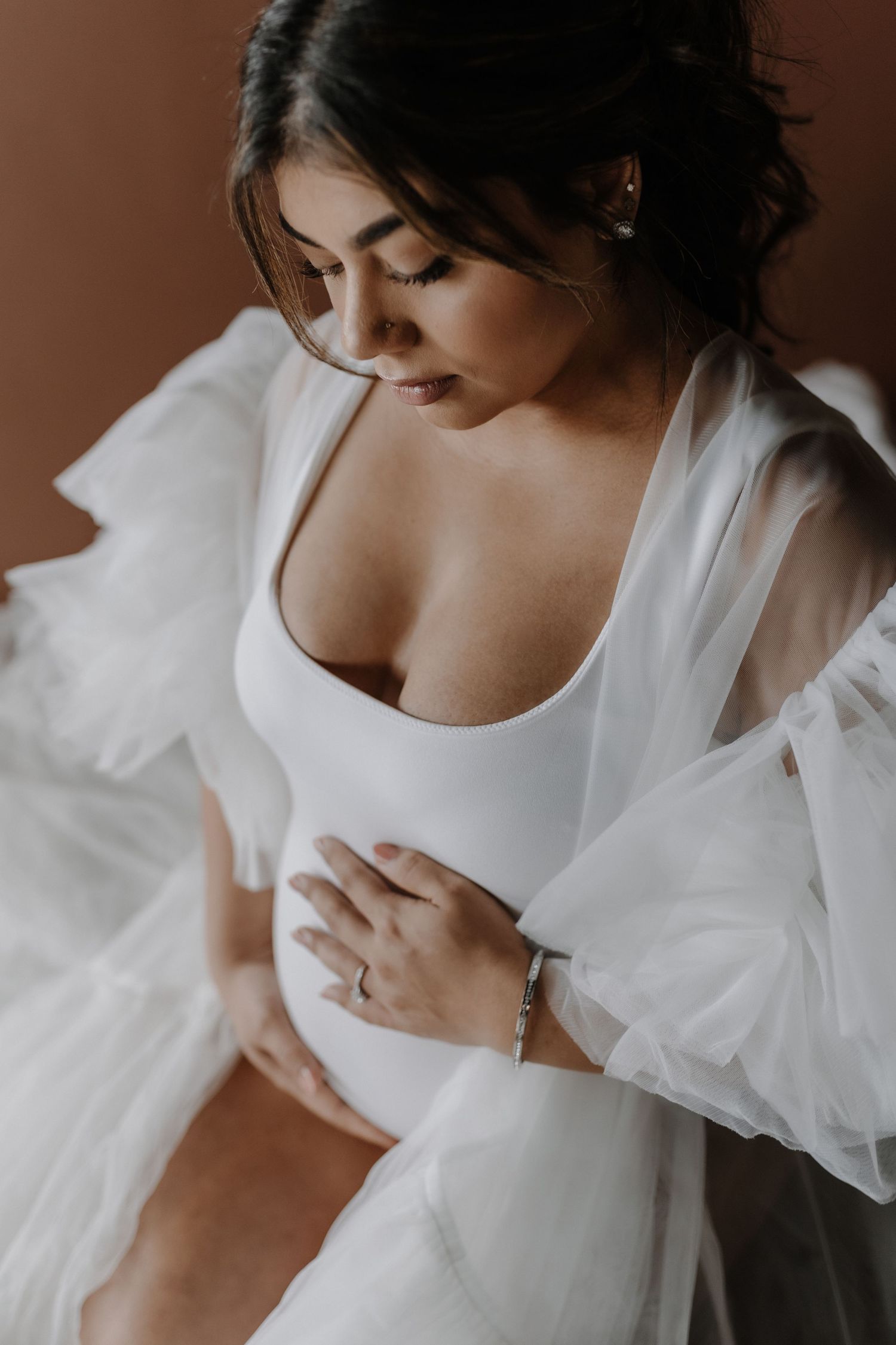 Soft morning light illuminates a white silk robe and delicate jewelry details.
